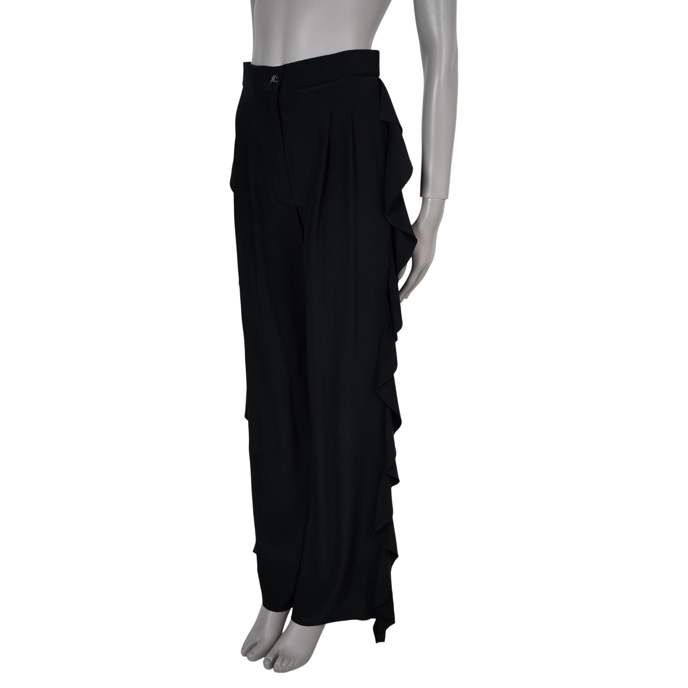 This 100% authentic Chanel pants in black silk (100% – please note the content tag is missing) embody refined elegance with a touch of drama. Designed with a high waist and wide legs, they feature cascading side ruffles that add fluid movement and