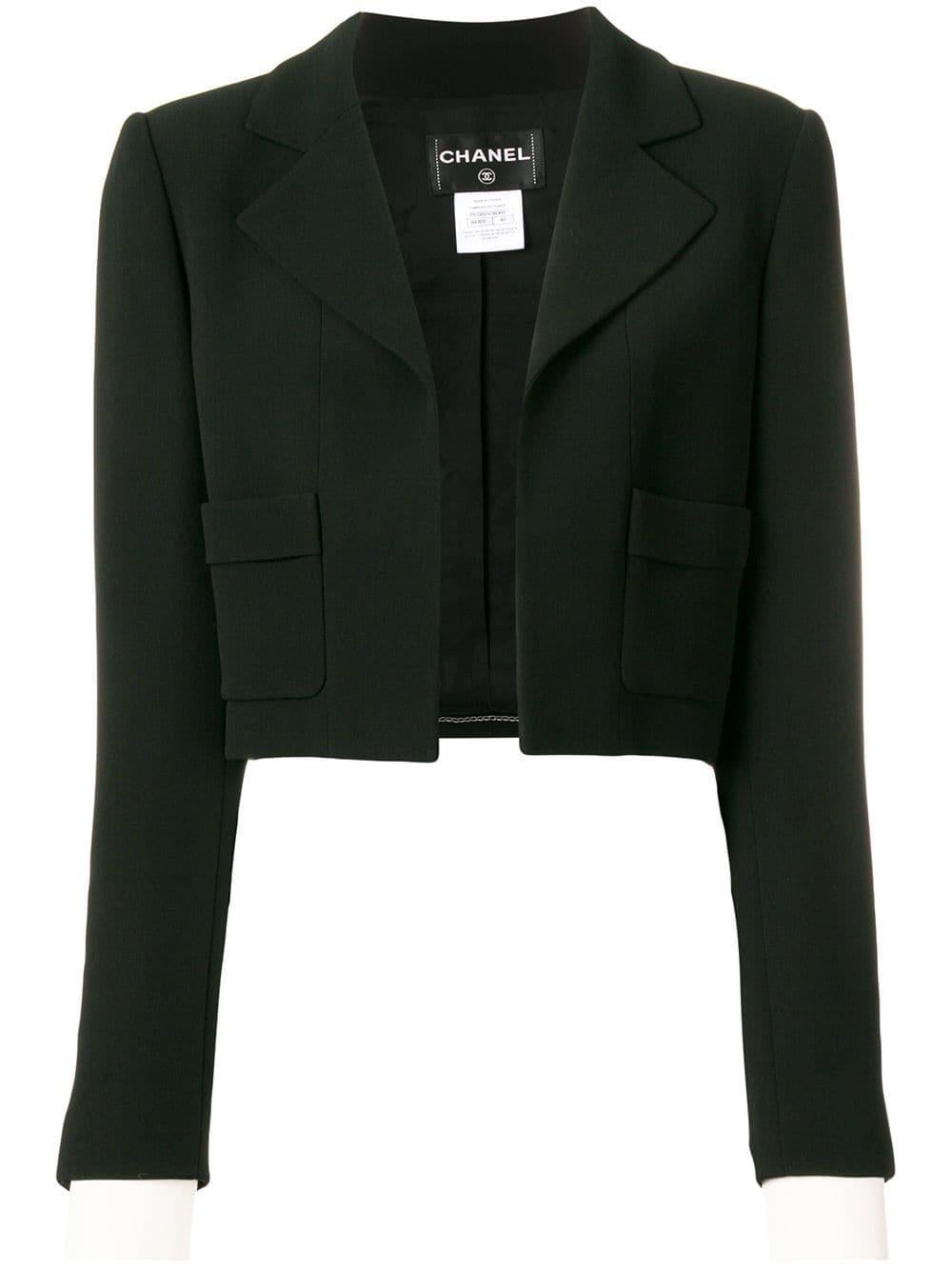This elegant Chanel jacket was crafted in France from black silk, the simple cropped style features classic lapels, no fastening, long sleeves, white detachable button cuffs and patch pockets. 

Colour: Black

Composition: 100% Silk

Size: 40 FR /