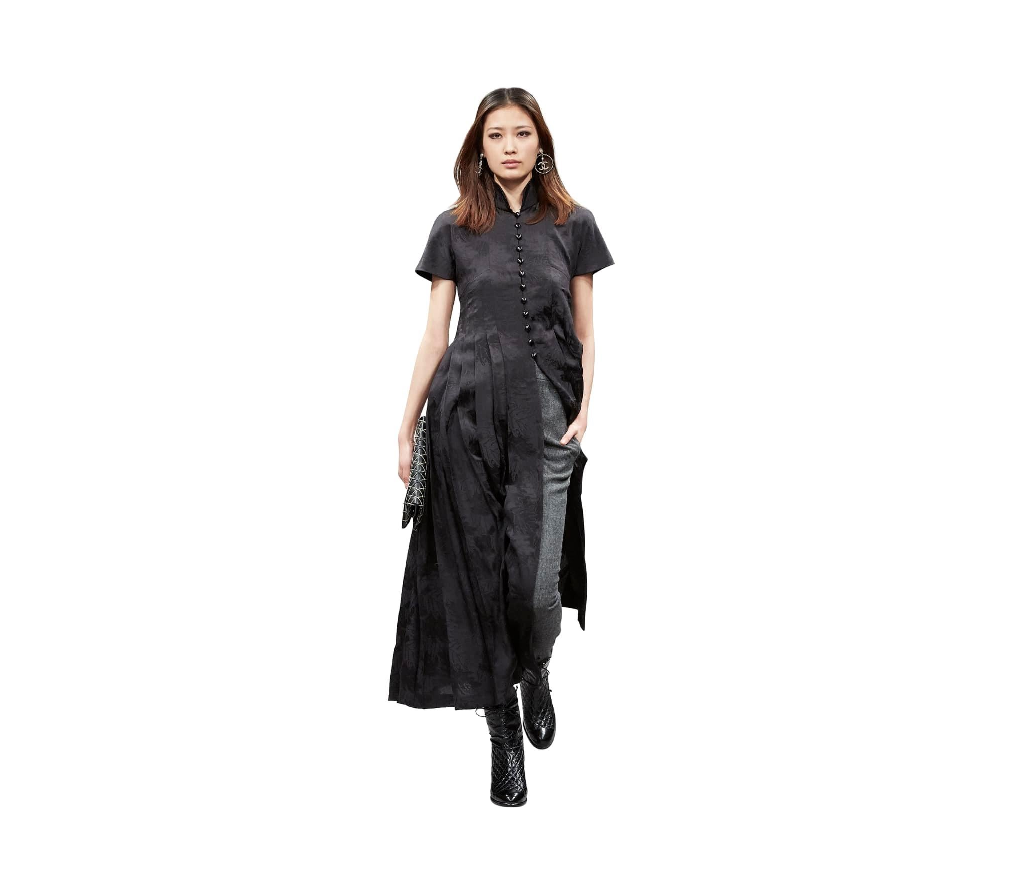 100% authentic Chanel Pre-Fall 2018 jaquard dress in black silk (100%). With a high front-slit till the waist, padded cap-sleeves, mandarin collar, leaf pattern and pleats. Meant to be worn over pants. Closes with black round CC-buttons in the