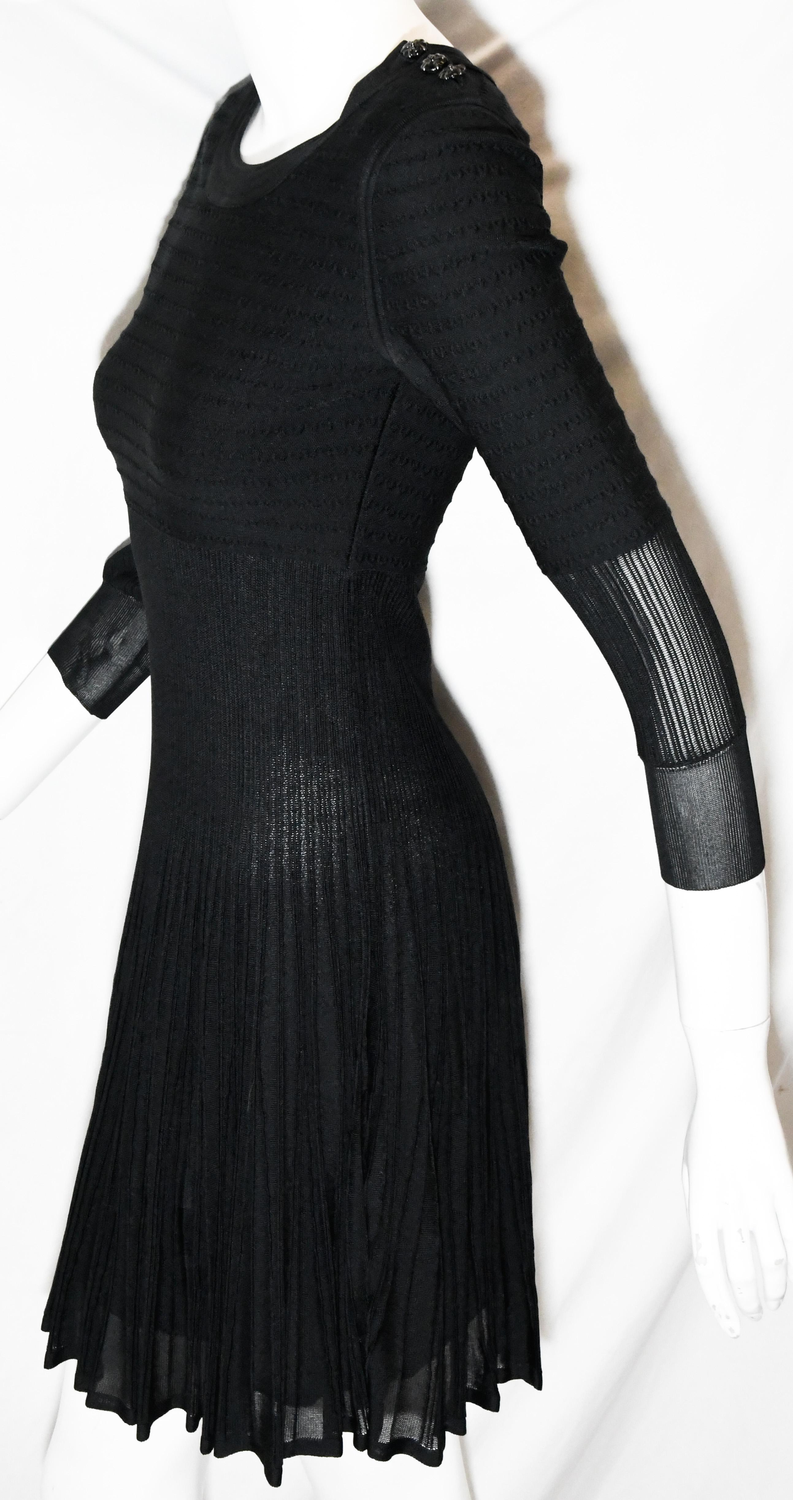 Chanel black knit silk blend dress from the 2009 cruise collection is a runway statement!  Composed with stretch silk and viscose on the upper torso then transitioning to silk ribbed pleats and flaring to a full skirt. The sleeves have the same