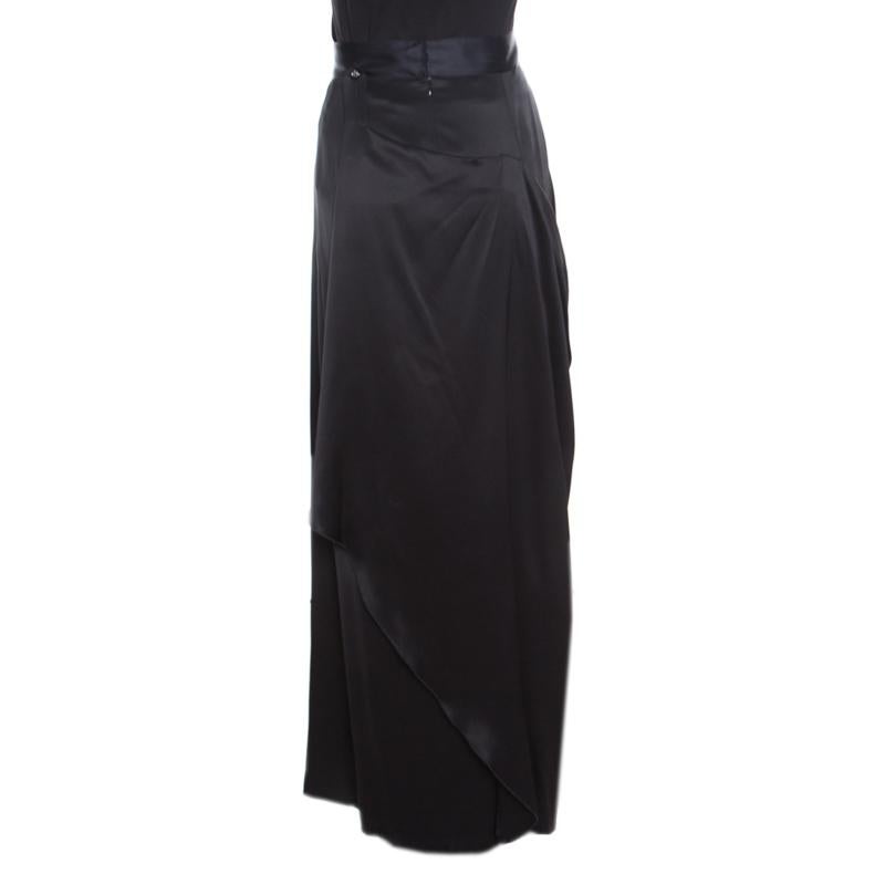 Wear an effortlessly elegant look with this minimalist yet chic skirt from Chanel in timeless black color. The piece comes crafted in luxurious silk lending the piece a gleaming finish and falls to a floor-sweeping length. It is styled in a draped