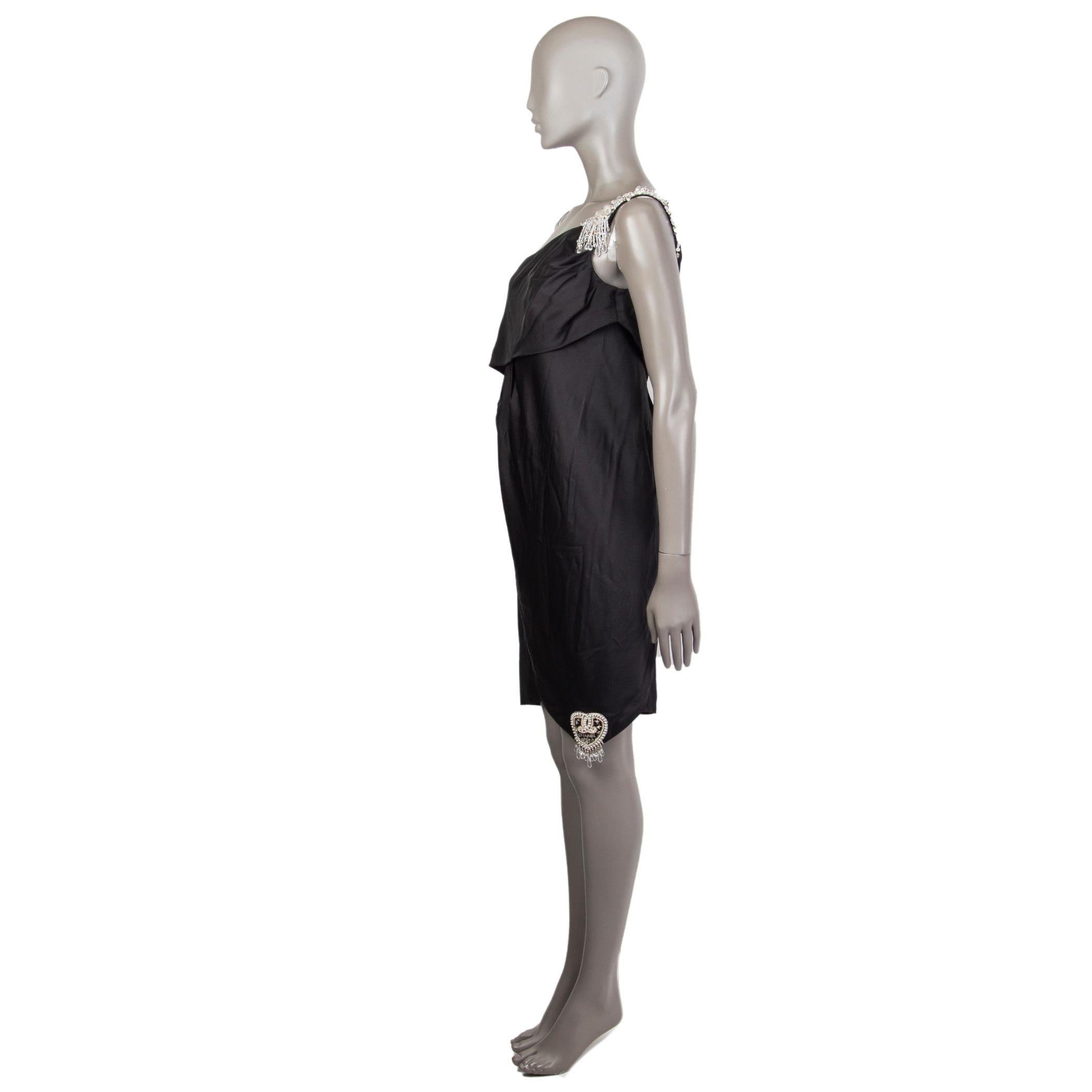 Mini robe Chanel embellie à une épaule en soie noire (100%) avec un détail d'application de perles Chanel 2008 sur le coin inférieur droit. Se ferme sur le côté avec une fermeture éclair dissimulée et six perles gravées cc en forme de diamant clair.