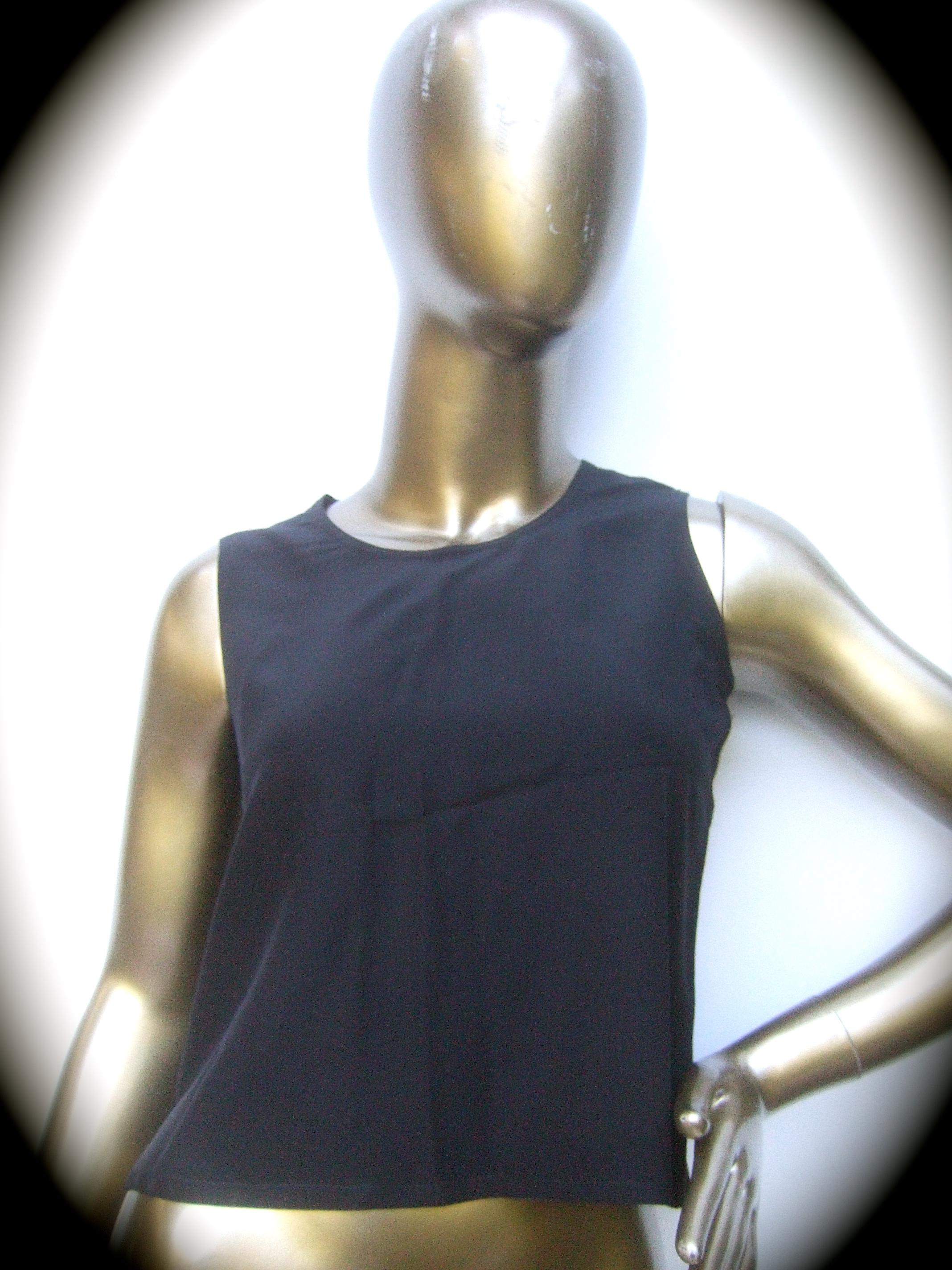 Chanel Black silk sleeveless petite shell top c 1980s (Petite)
Constructed with luxurious breezy silk fabric 
The stylish Chanel silk shell makes a versatile timeless garment 
The back neckline secures with a single snap button 
Labeled: Chanel 
No
