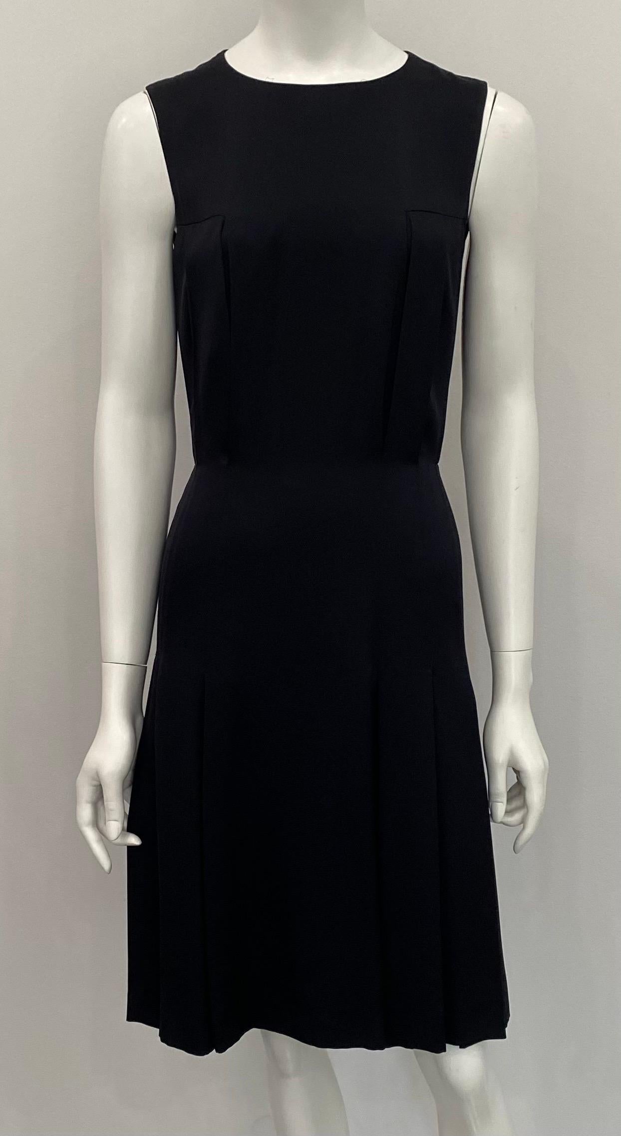 Chanel Black Silk Sleeveless Dress - 36 - Circa 01A. This classic black sleeveless dress by Chanel is fully lined in the classic camellia and cc print silk. The bodice of the dress has a round neckline and is someone fitted with three front pleat