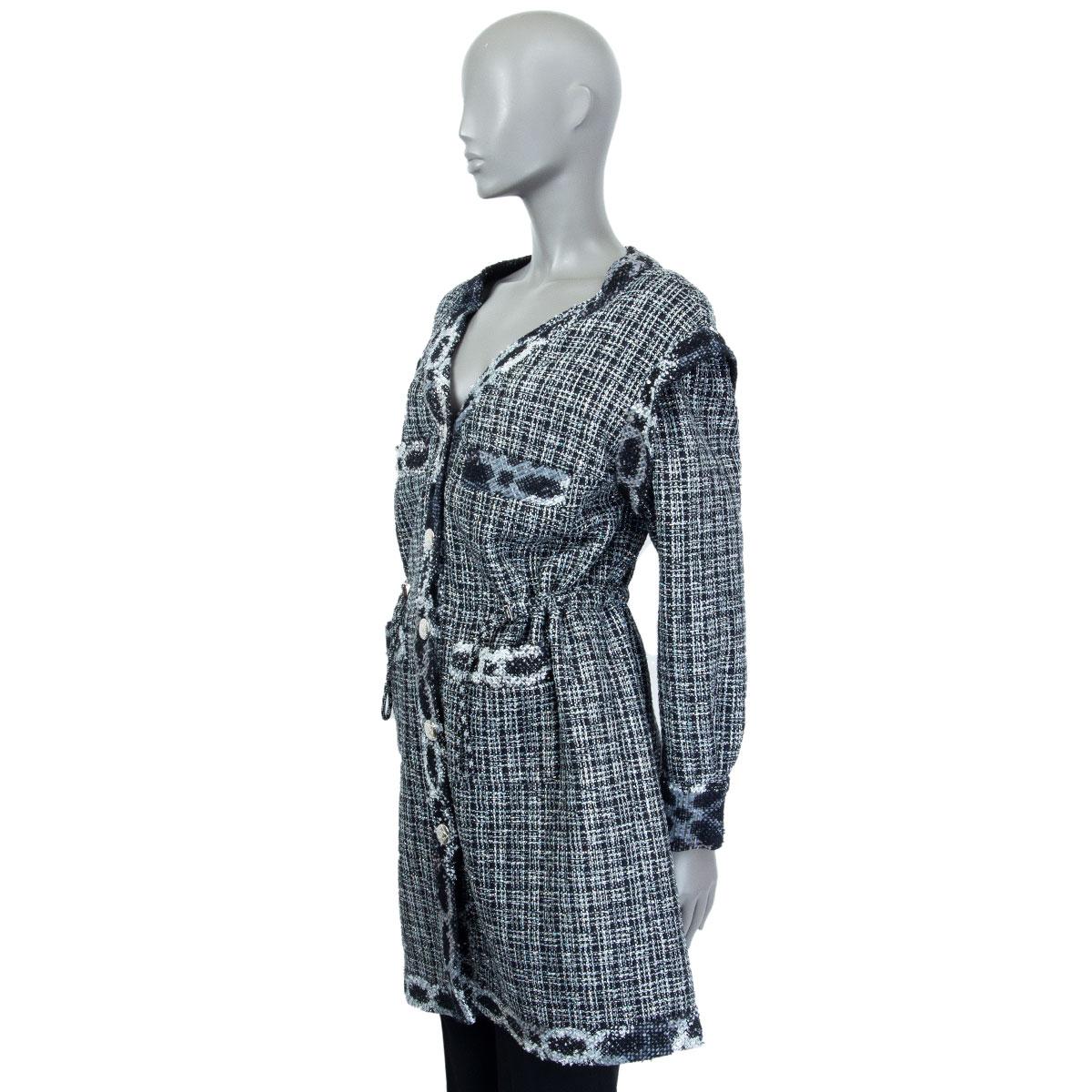 authentic Chanel v-neck tweed coat in black, dark blue, grey, silver, and metallic cotton (51%), acetate (34%), polyamide (10%) and polyethylene (5%). Lined in black silk (100%).  Opens with 6 buttons on the front and has 2 chest-pockets and