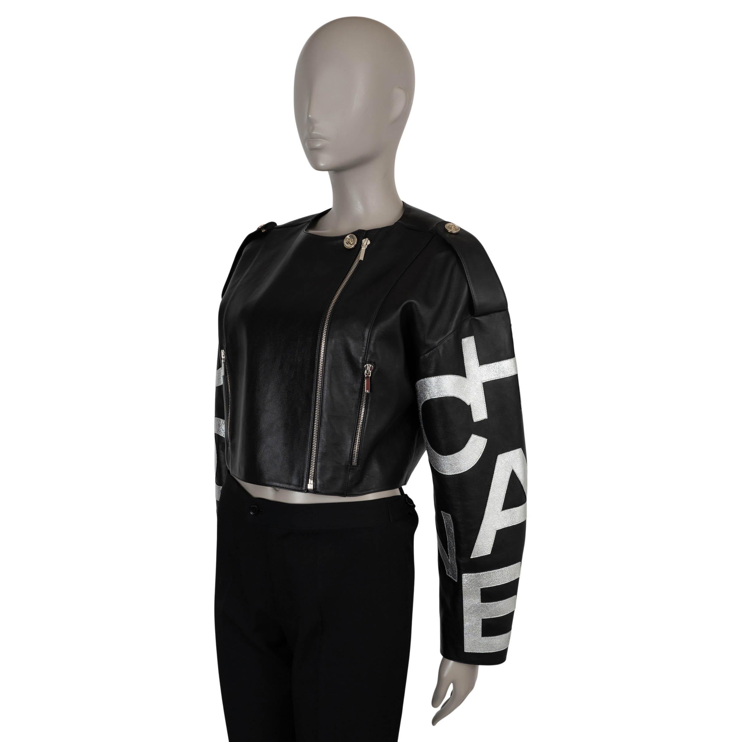 Diese 100% authentische Chanel Bikerjacke aus schwarzem Lammleder ist mit metallisch-silbernen Signaturmotiven an den Ärmeln verziert. Das Modell in Oversized-Silhouette verfügt über überschnittene Schultern, eine verkürzte Länge, geknöpfte
