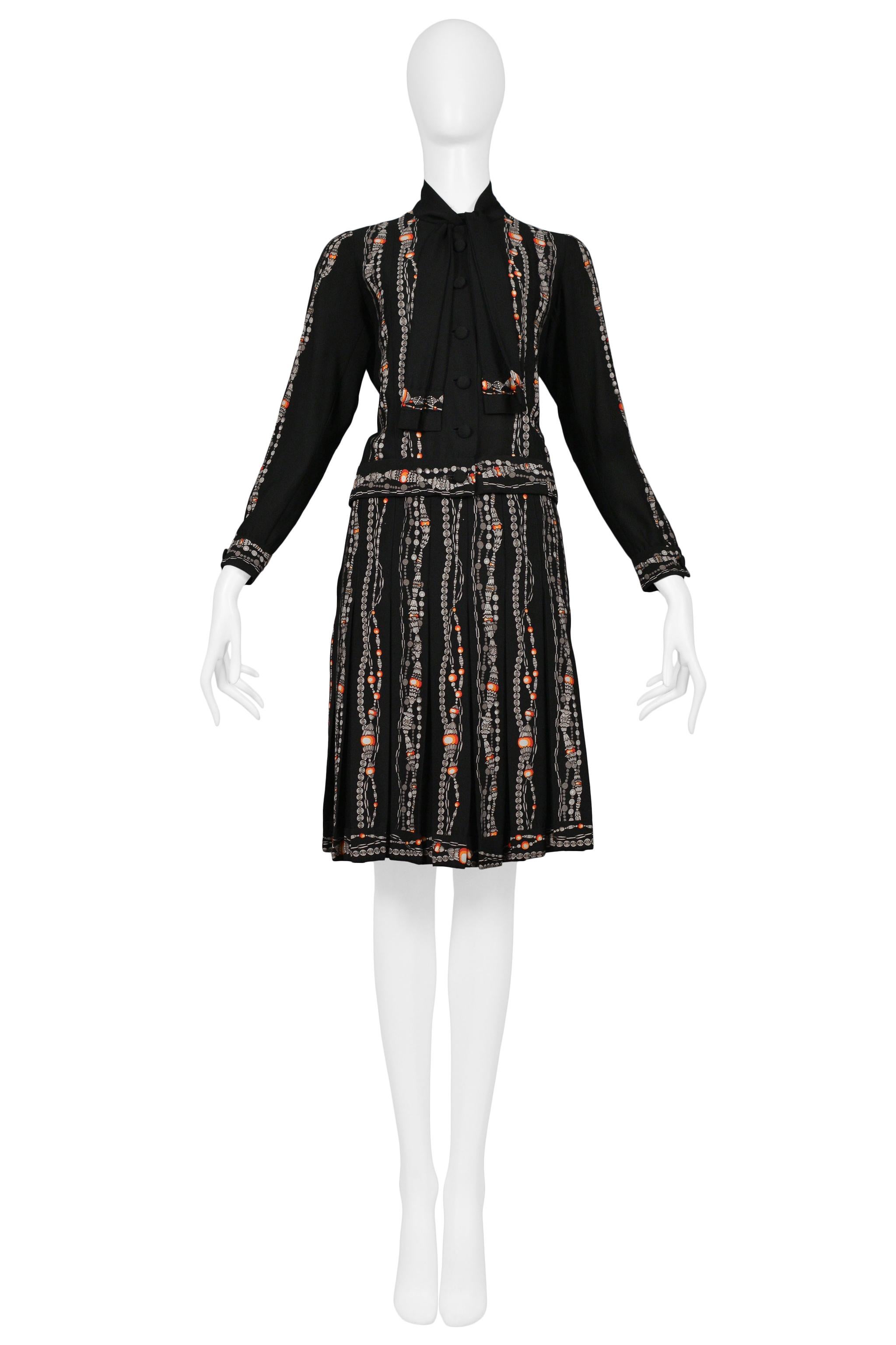Resurrection Vintage is excited to offer a vintage Chanel by Karl Lagerfeld black skirt suit featuring a button front jacket, bow collar, covered buttons, iconic bead and pearl necklace print, interior gold chain weighting, and classic skirt. 