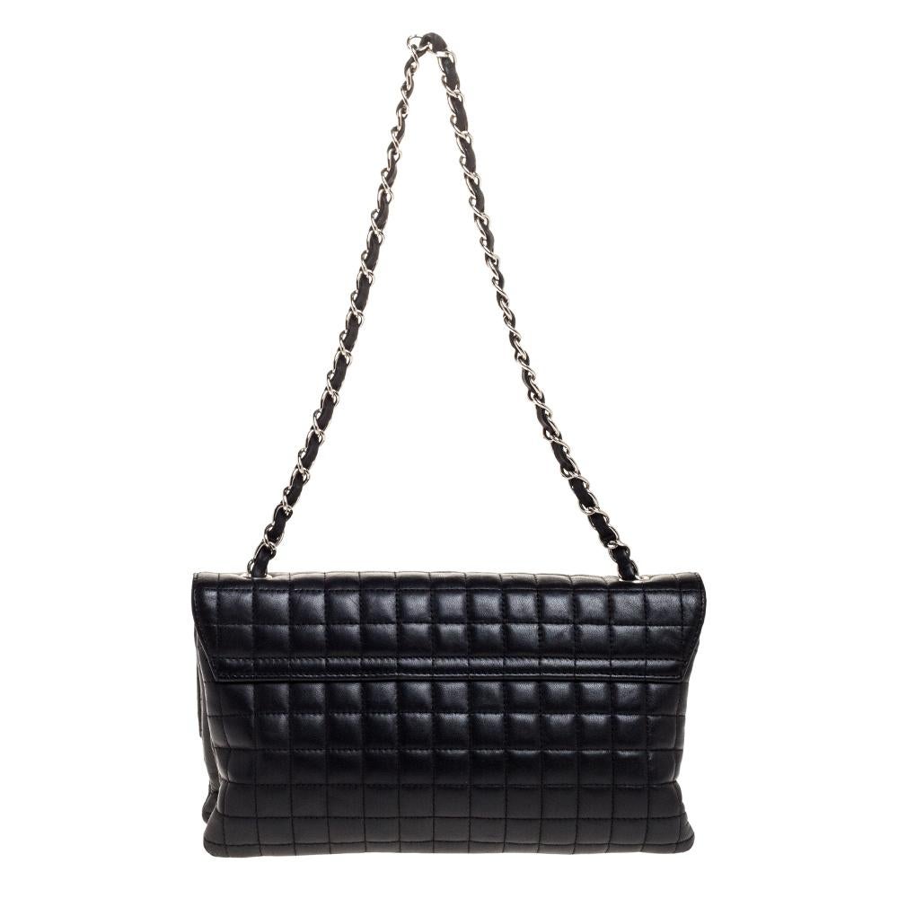 This Chanel black shoulder bag is simply gorgeous! It has been beautifully crafted from leather and designed in their signature square quilt with details like No.5, the CC logo and a Camellia applique on the flap. The bag also hosts a well-sized