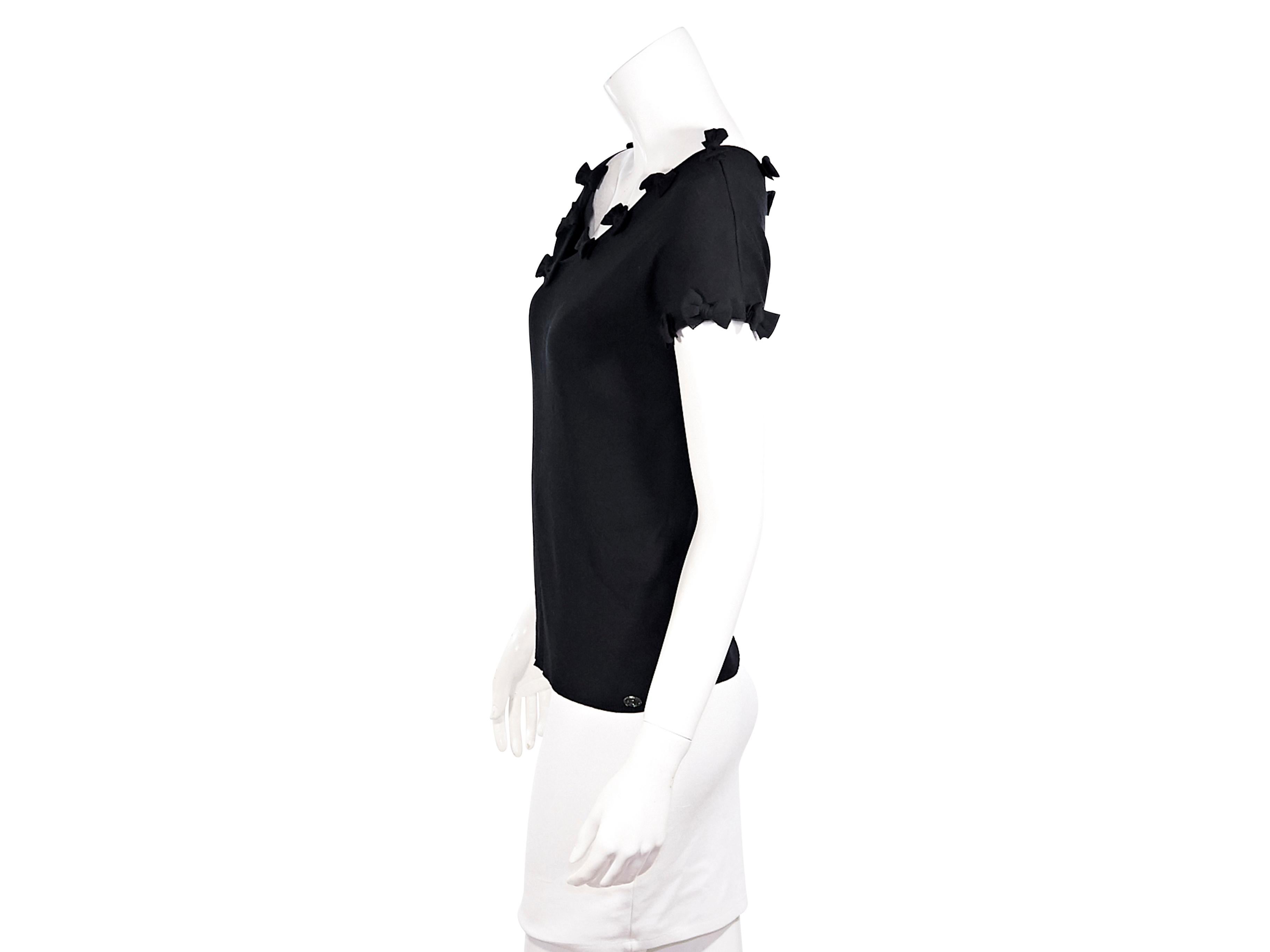 Product details:  Black stretch-cotton top by Chanel.  From the Spring/Summer 2009 collection.  Asymmetrical v-neck accented with bows.  Short sleeves.  Pullover style.  34