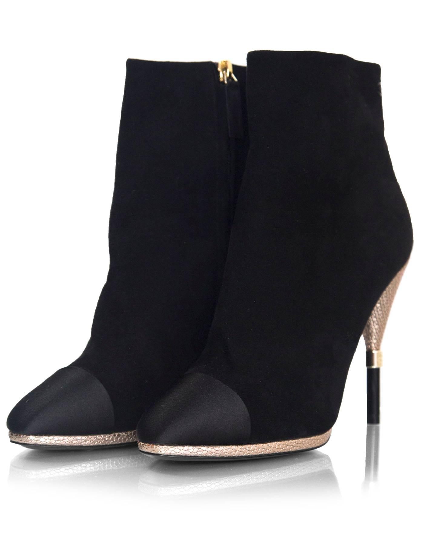 Chanel Black Suede & Satin Cap-Toe Ankle Boots Sz 39C NEW
Features textured light goldtone and black laquered heels with CHANEL logo

*Please note this is a wide-fit shoe*

Made In: Italy
Color: Black, gold
Composition: Suede, satin, metal
Sole