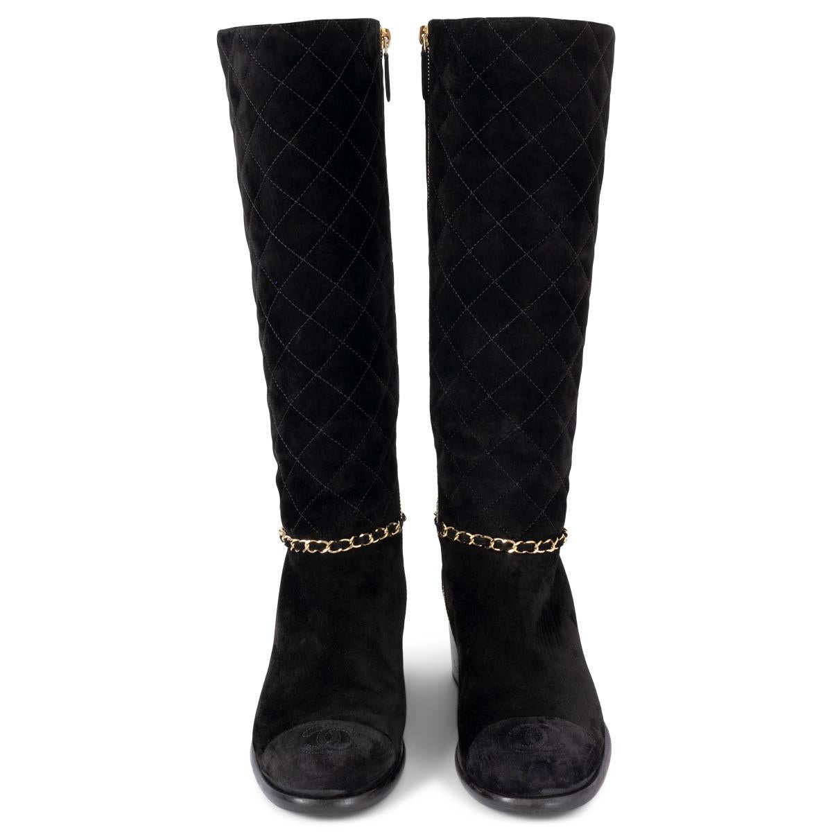 100% authentic Chanel knee-high block-heel boots in black quilted suede featuring signature gold-tone chain detail around the ankle. Open with a zipper on the inside and are lined in smooth black leather. CC logo stitching on cap toe. Have been worn