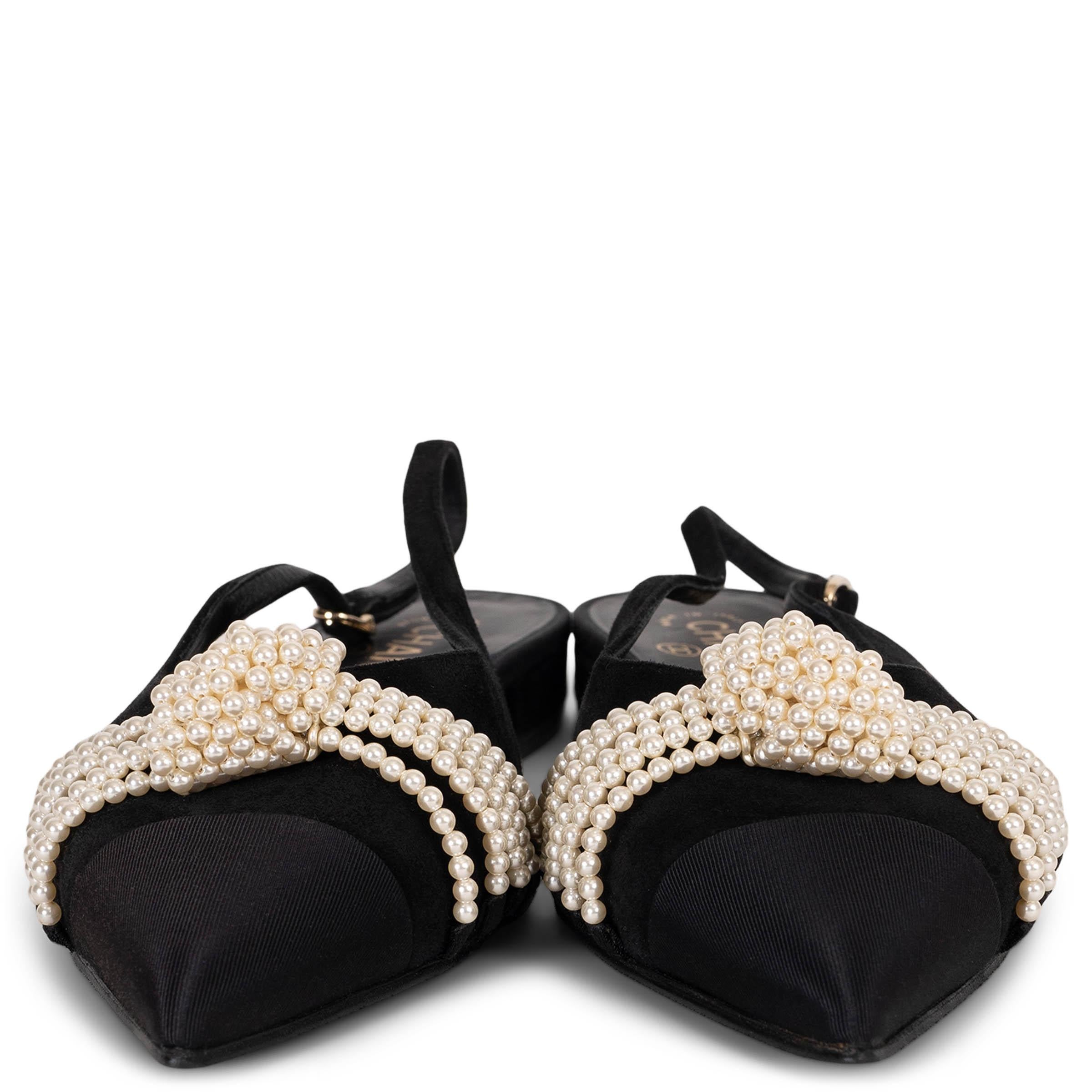 Diese 100% authentischen Chanel Slingback Flats aus schwarzem Wildleder sind mit fünf Strängen perlweißer Kunstperlen geschmückt, die am Vorderblatt geknotet sind. Die spitz zulaufende Schuhspitze mit Ripsbandkappe ist mit einem kleinen,
