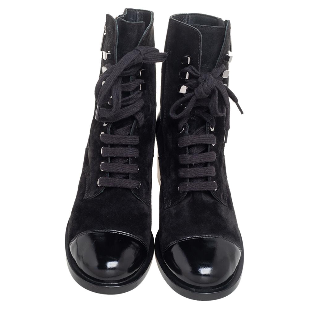 Embrace current trends and grab these Combat boots by Chanel today! They are made from black suede and leather on the exterior and showcase lace-up detailing and zippers on the vamps. These boots are fitted with black-toned hardware and raised on