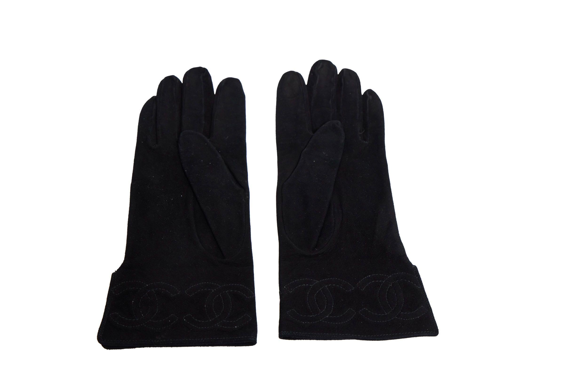 Super elegante Chanel Handschuhe aus schwarzem Wildleder mit aufgesticktem CC-Logo am Rand. Sie haben die Größe 7 und sind brandneu. Das Futter ist aus Seide und weiß.
