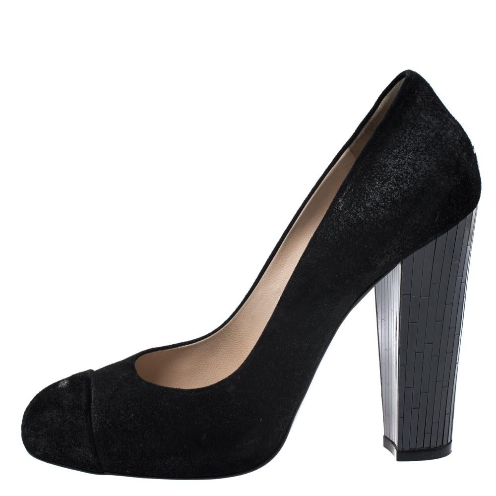 This pair of pumps by Chanel is a timeless classic. Step out in style while flaunting these black suede shoes, ideal for all occasions. They feature cap toes, CC logo details on the counters, and 11 cm high block heels.

