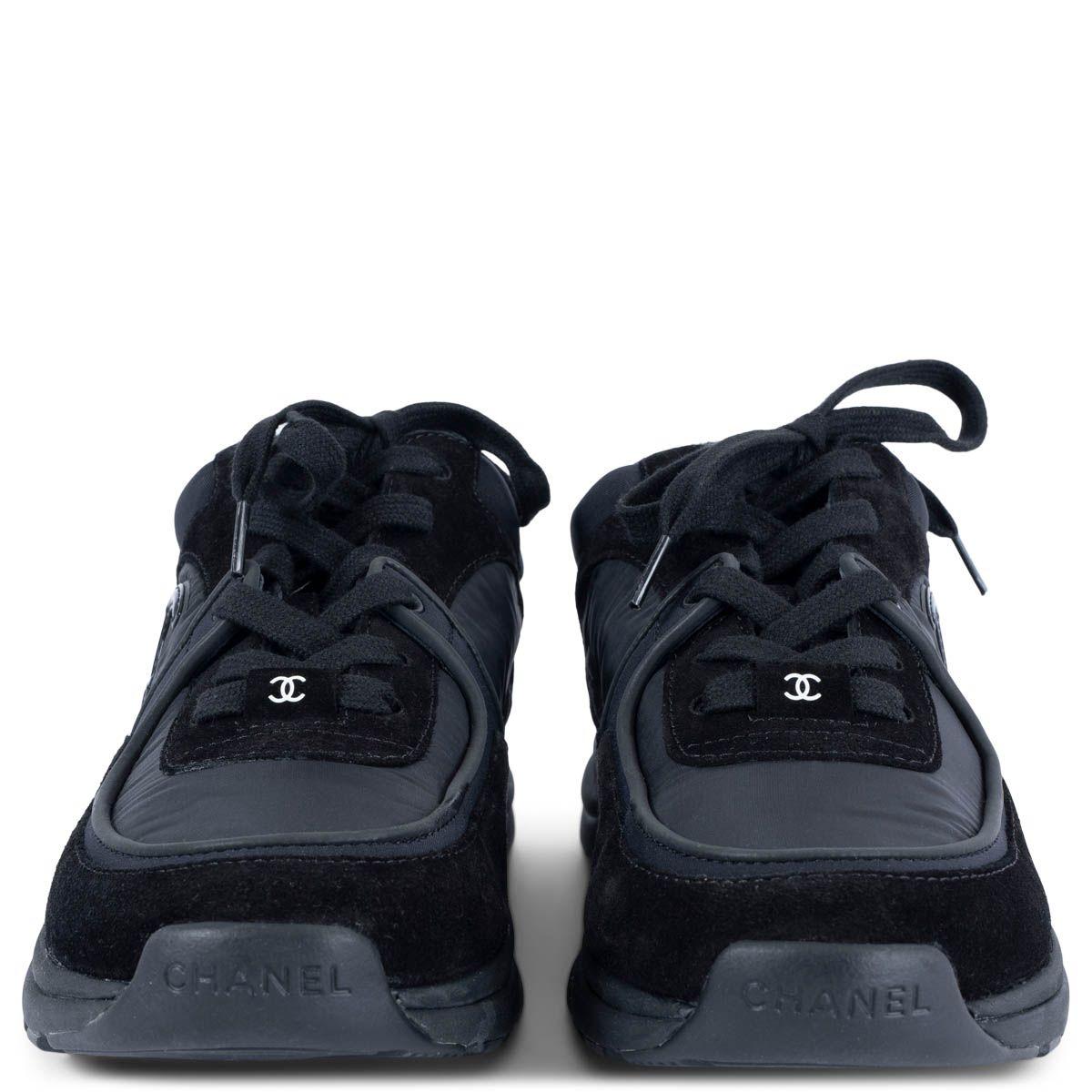 100% authentische Chanel Sneaker zum Schnüren aus schwarzem Wildleder und Nylon. Das Design zeichnet sich durch schwarze Gummisohlen und ein glänzendes CC-Logo an der Seite aus. Teil der Revolving Collection'S. Sie wurden ein- oder zweimal getragen