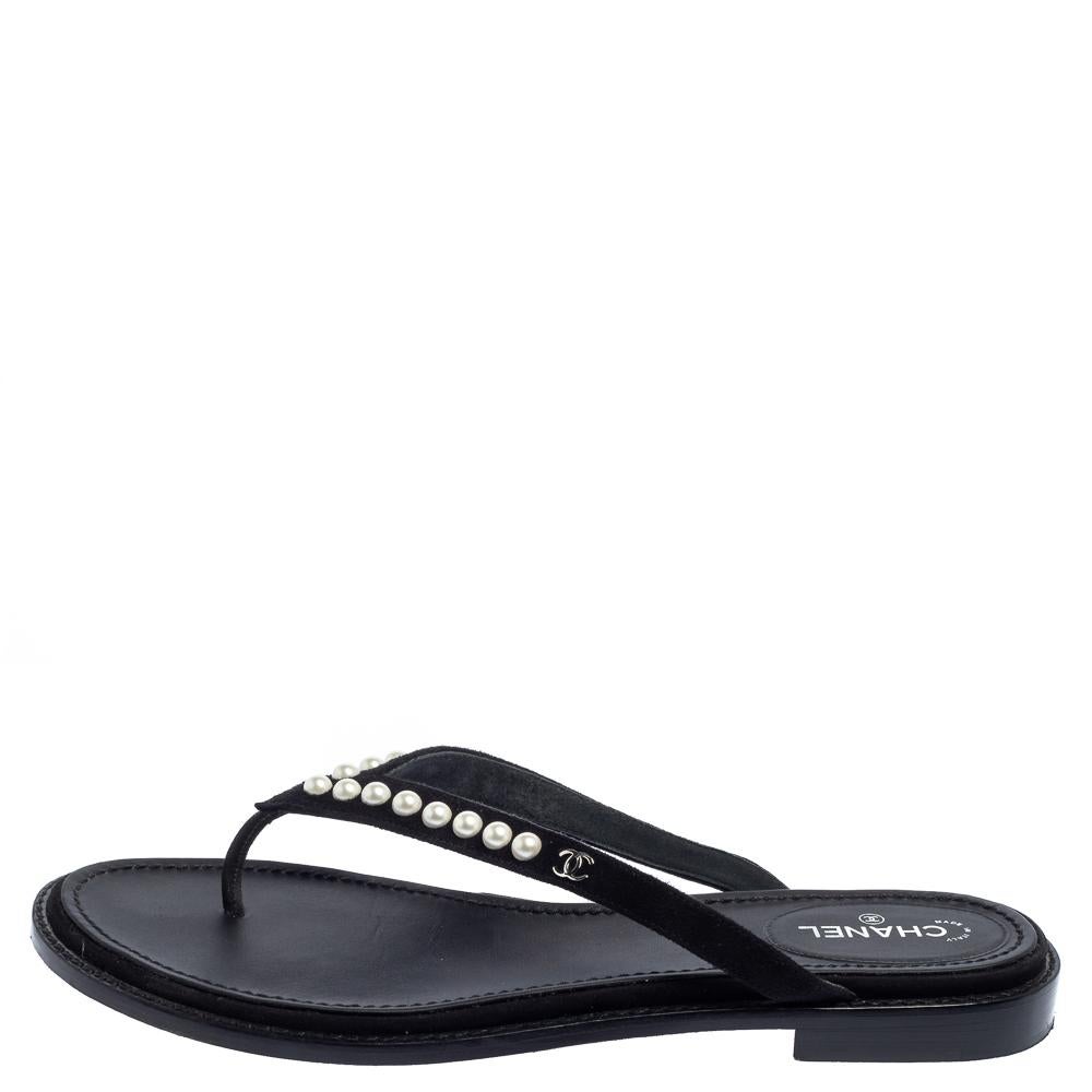 Dieses wunderschöne Paar Sandalen aus hochwertigem Wildleder wird Ihrem Look einen klassischen Touch verleihen. Sie haben ein Zehensteg-Design mit den charakteristischen Perlen- und CC-Logo-Details auf den Riemen. Mit diesen wunderschönen