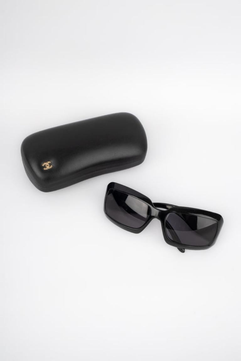 Chanel - (Made in Italy) Black sunglasses ornamented with a pearly cc logo on the arm.

Additional information:
Condition: Decent condition
Dimensions: Length: 16 cm

Seller Reference: ACC154
