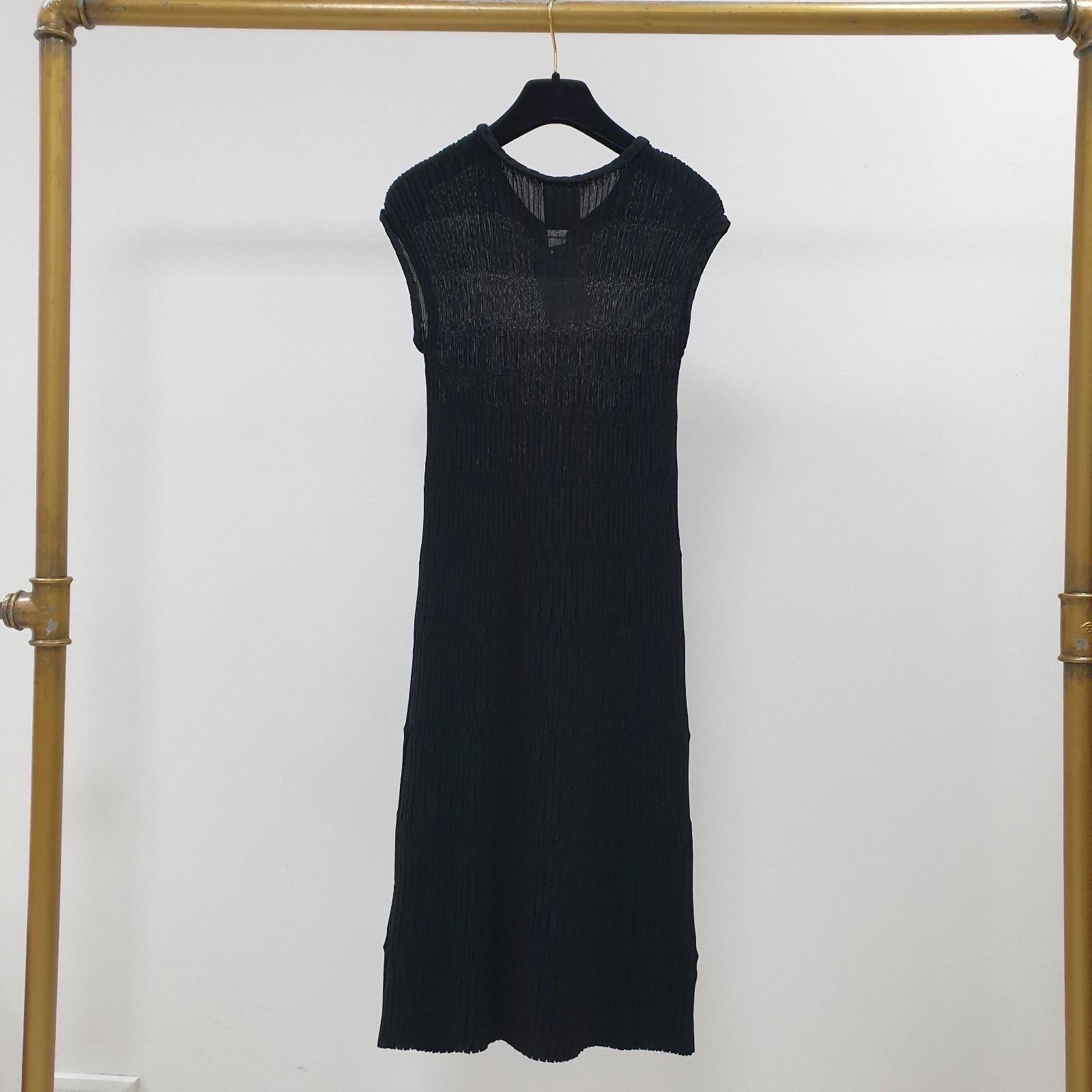 Authentic Chanel minimalistisch göttlich in einem schwarzen Strick, ist dieses Kleid eine luxuriöse, aber praktische Investition, die Sie Saison für Saison tragen können.

Schöne Chanel 2 Knöpfe vorne um den Halsausschnitt.

Sz.34
Ausgezeichneter
