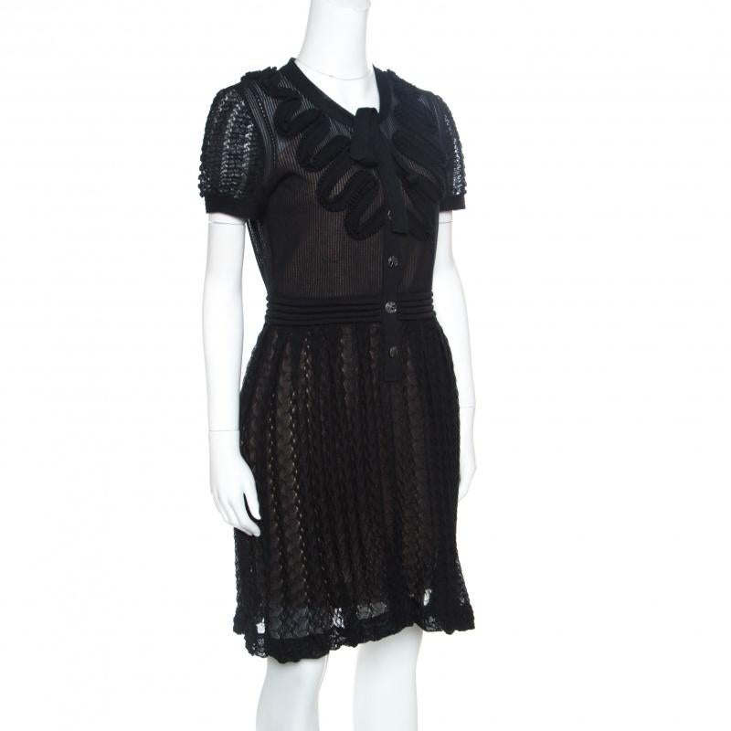 From Chanel's 2010 SS collection twirls in this black dress that has been finely tailored from quality fabrics and designed with textures, ruffle appliques and a tie detail. Front buttons are provided to help you slip into it.

Includes: The Luxury