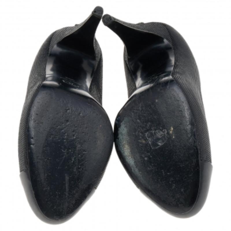 This pair of pumps from the house of Chanel is just what you need to take your style quotient a few notches higher. Made from textured black leather, their versatile design features patent leather cap toes and the CC logo on the high heels.