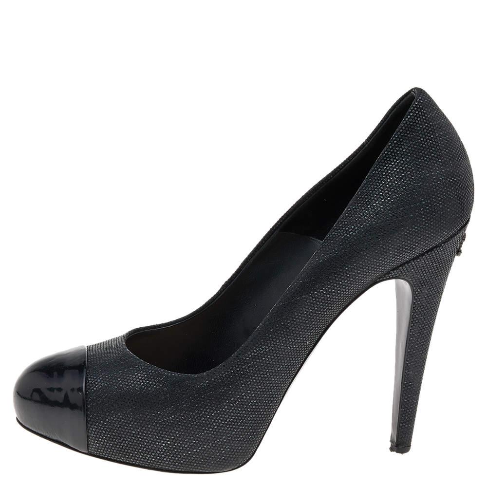 This pair of pumps from the house of Chanel is just what you need to take your style quotient a few notches higher. Made from textured black leather, their versatile design features patent leather cap toes and the CC logo on the high heels.

