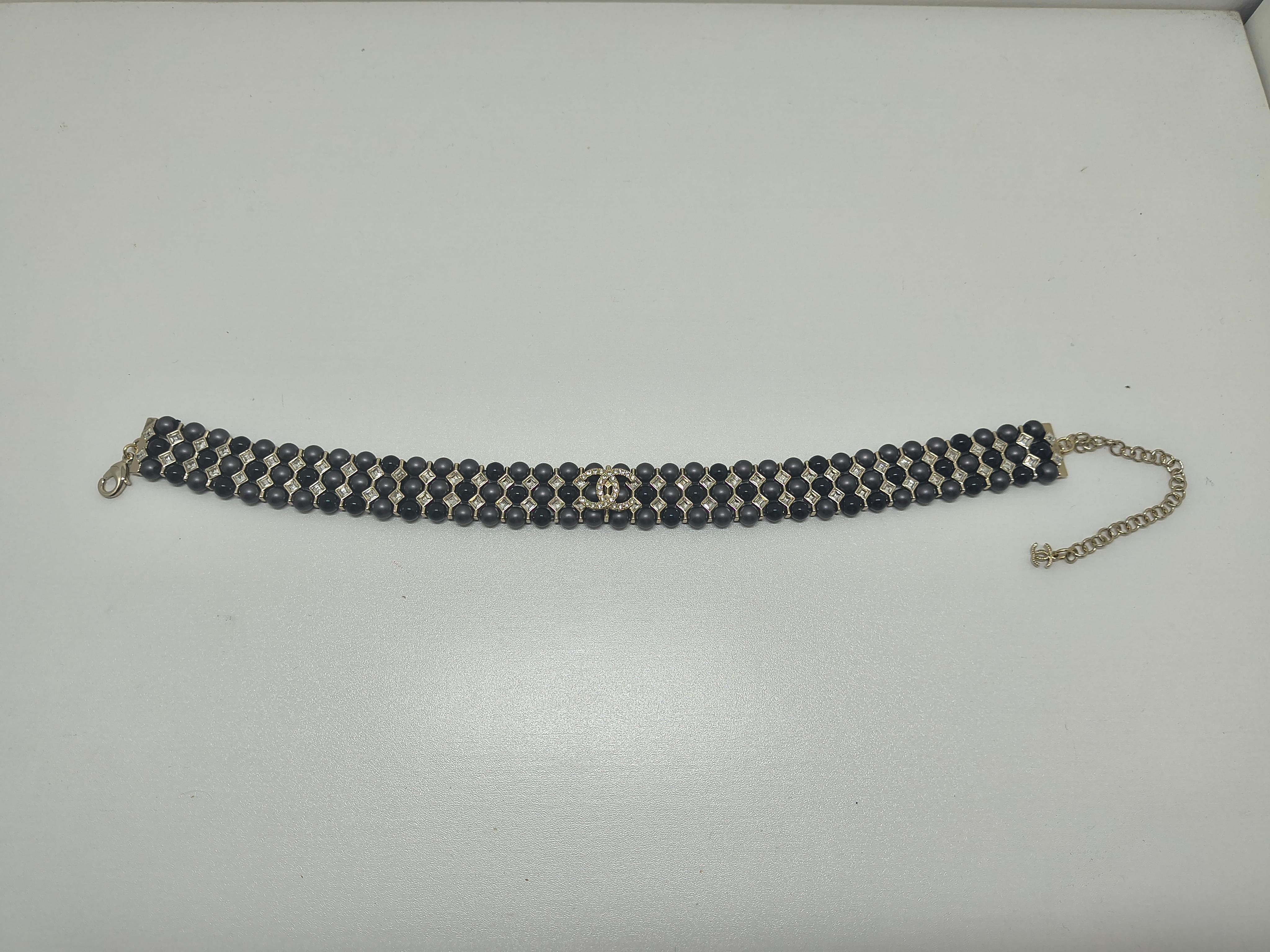 Fai una dichiarazione audace ma elegante con questo splendido girocollo Chanel della Collection'S Winter. Realizzato con un'attenzione meticolosa ai dettagli, questo girocollo a tre file presenta un'alternanza di perline nere opache e lucide,