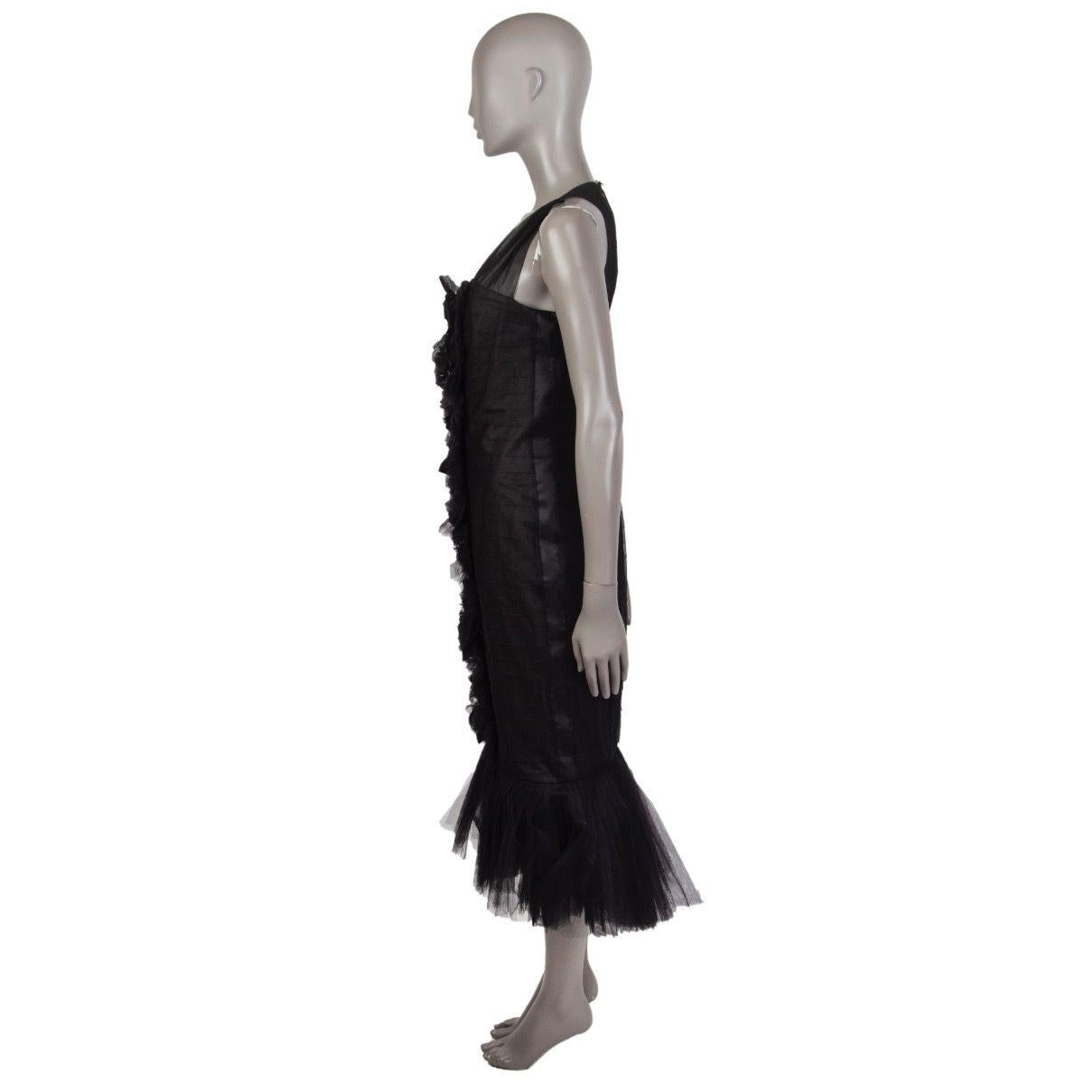 Chanel Trumpet dress in black tulle with ruffled panel and embellished flower applications on the front, and keyhole back. Closes with rhinestones button at the back of the neck and hook and invisible zipper on the back. Lined in black organza. Has