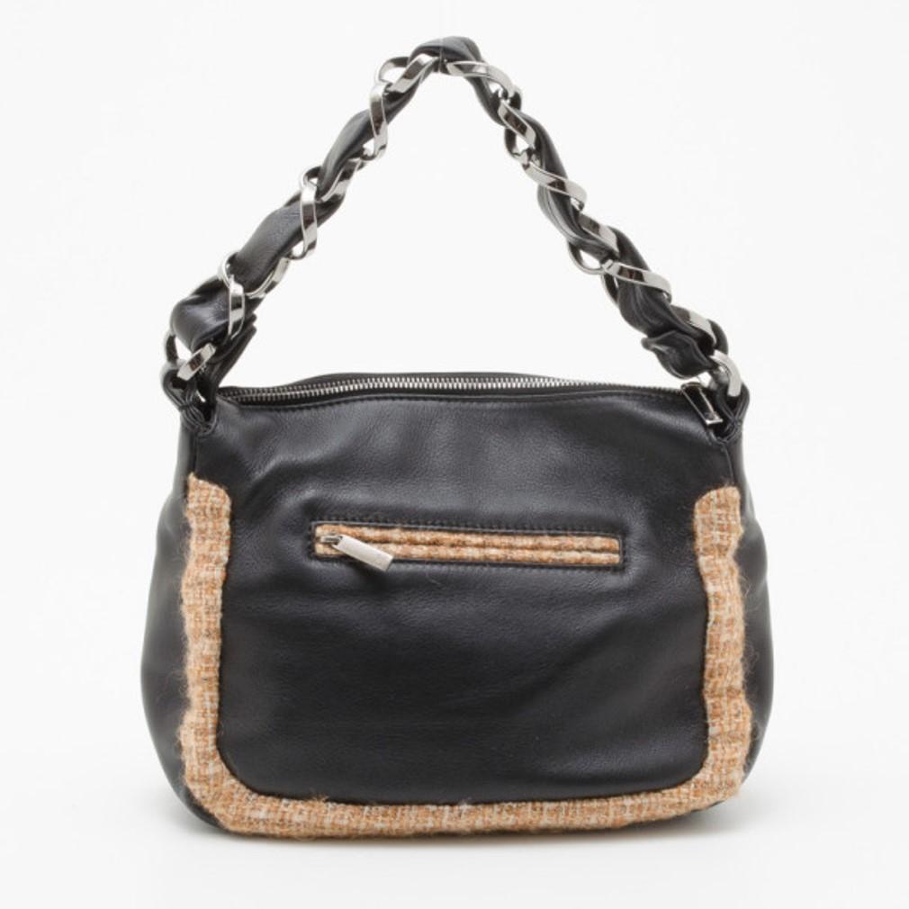 This Chanel tweed and leather shoulder bag is a vintage must have! It is crafted from leather and jute and features stylish edges, a front pocket snap closure and a back zip pocket. Carry it comfortably thanks to its chain and leather strap. The