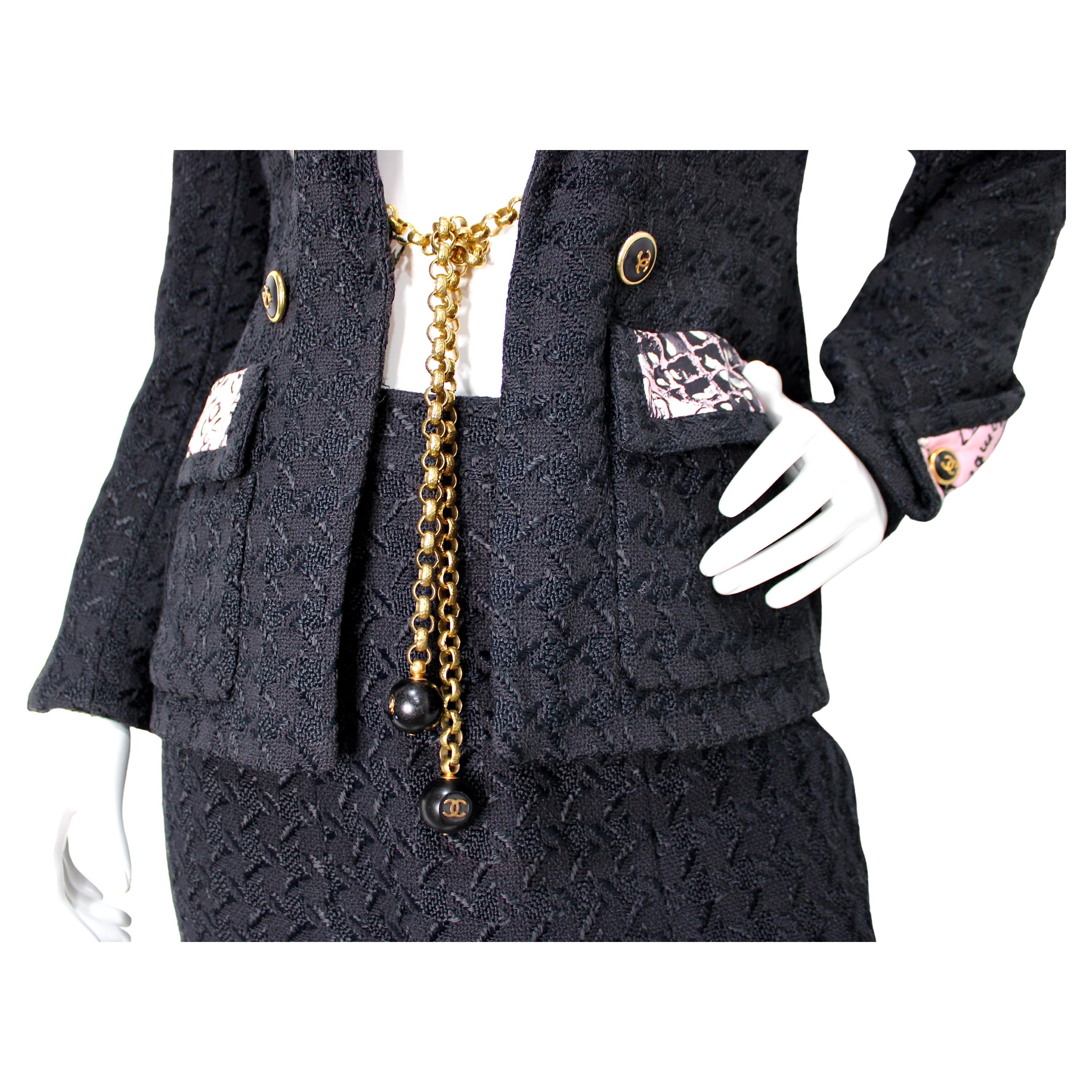 This Chanel Black Tweed Houndstooth 
Pink Print Jacket 
Skirt Suit Set from 1993 exemplifies timeless elegance with a bold, modern twist. The classic black tweed houndstooth pattern serves as the sophisticated foundation, while the vibrant