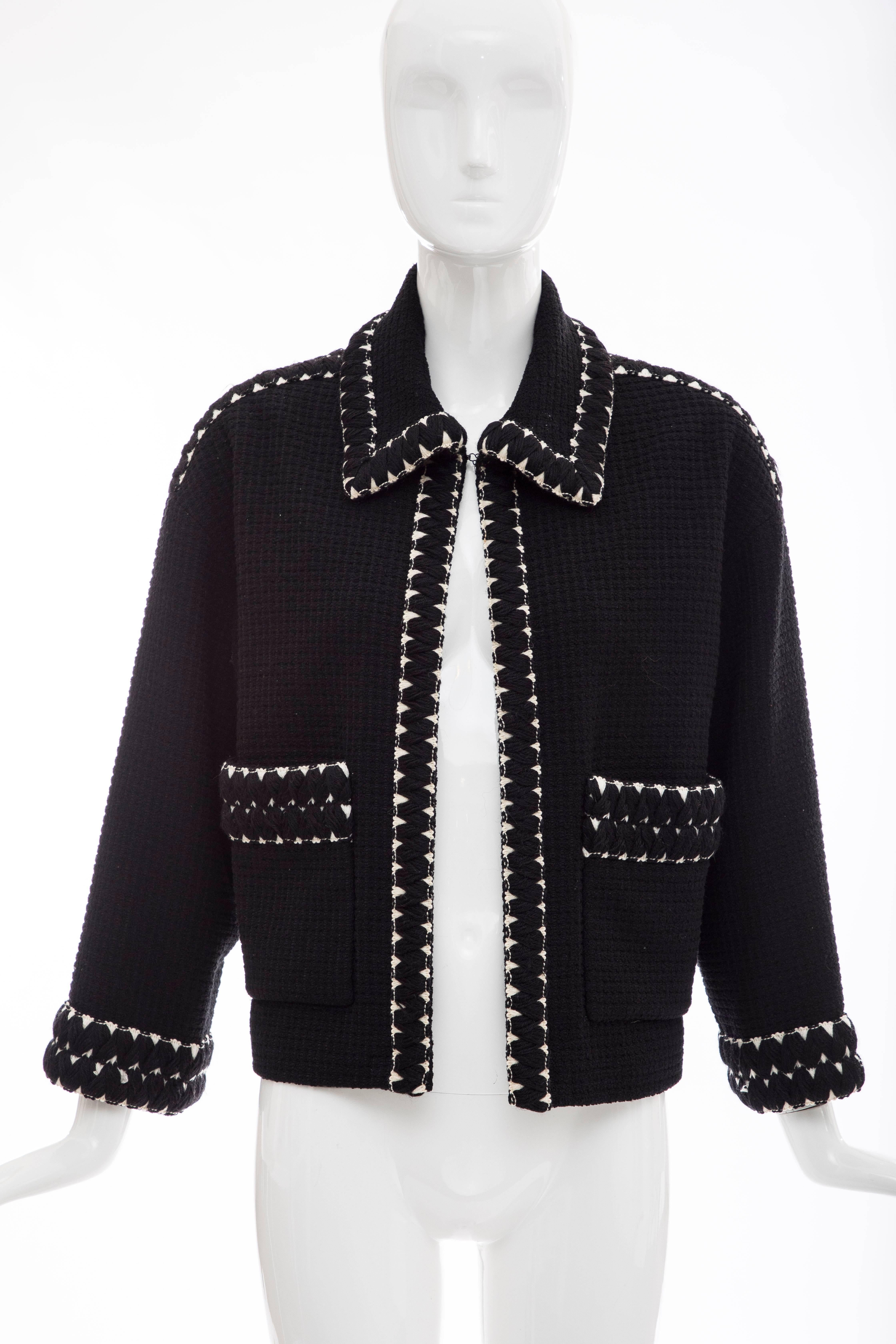 Chanel, Circa 1980's black tweed jacket featuring embroidered trim throughout, pointed collar, three-quarter sleeves, dual patch pockets, single hook closure at front and printed silk lining. 

No Size Label
Bust: 42, Waist 44, Shoulder 21, Length