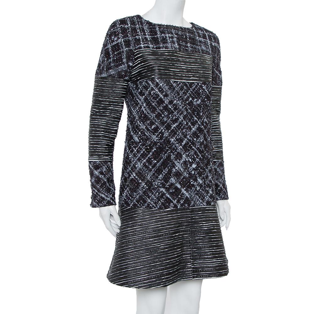 Elegant and modern are two words that pretty much define this Chanel dress. It is a beautiful creation cut from quality tweed fabric and leather. The dress features a paneled design, long sleeves, and a round neck.

