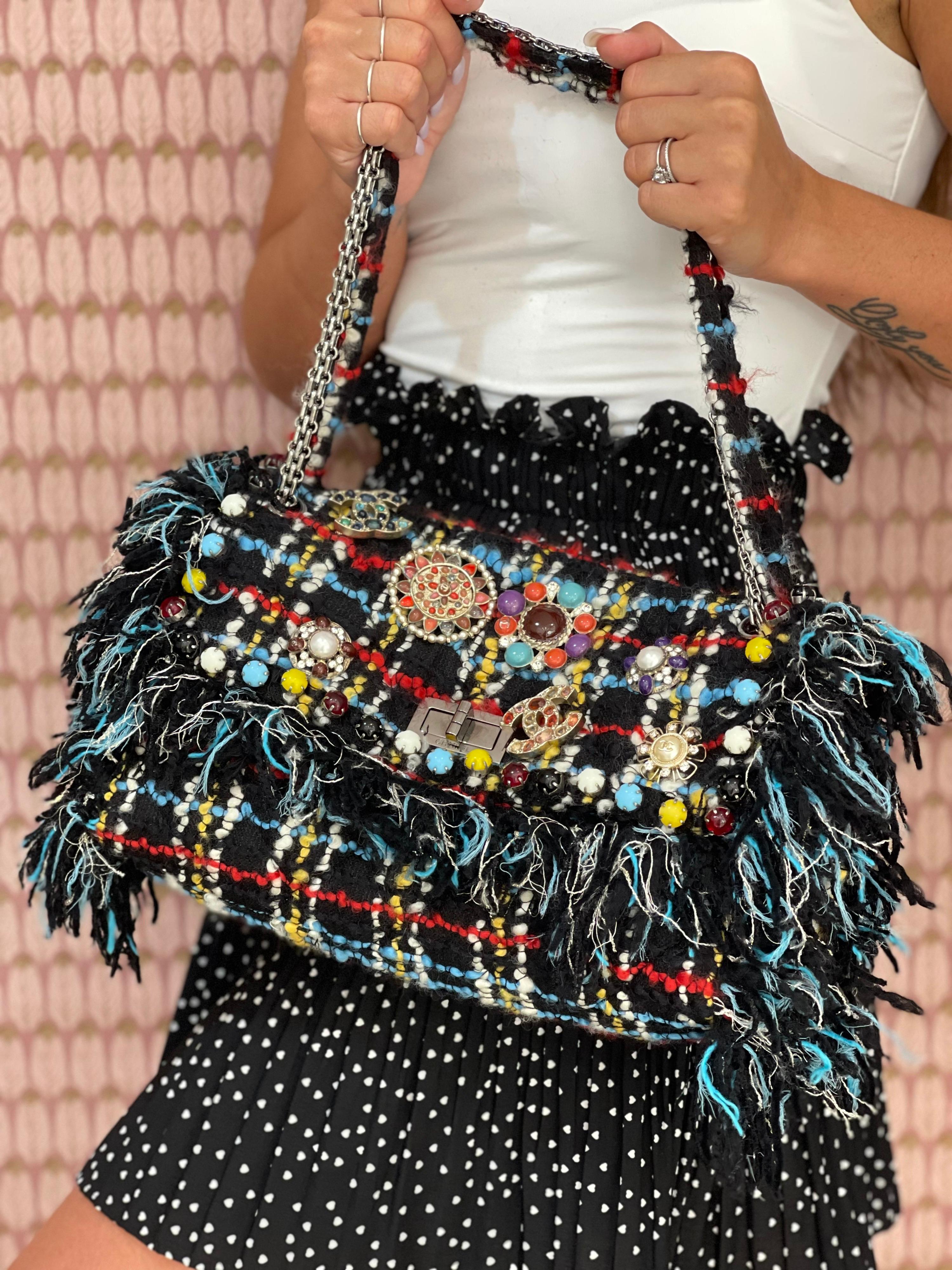 Chanel signed bag, limited edition, made of black and multicolor tweed, with silver hardware. Equipped with an interlocking closure, internally covered in black canvas, quite roomy. Equipped with a tweed and chain sliding shoulder strap and internal