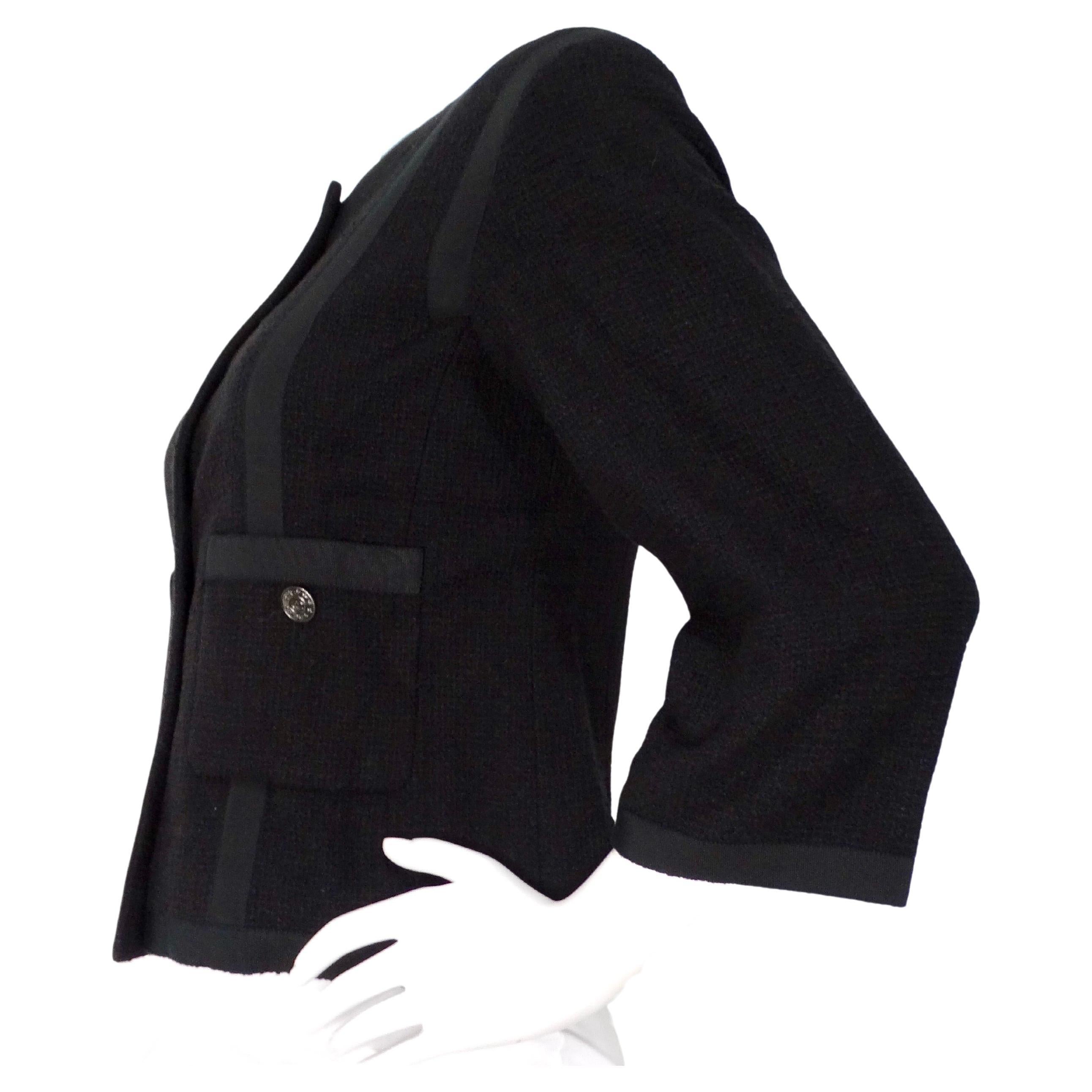 La Chaqueta con mangas recortadas Chanel de tweed negro y forro de seda personifica la elegancia atemporal y la artesanía sofisticada. Confeccionada en lujoso tweed negro, esta chaqueta desprende el encanto clásico de Chanel, realzado por el suave