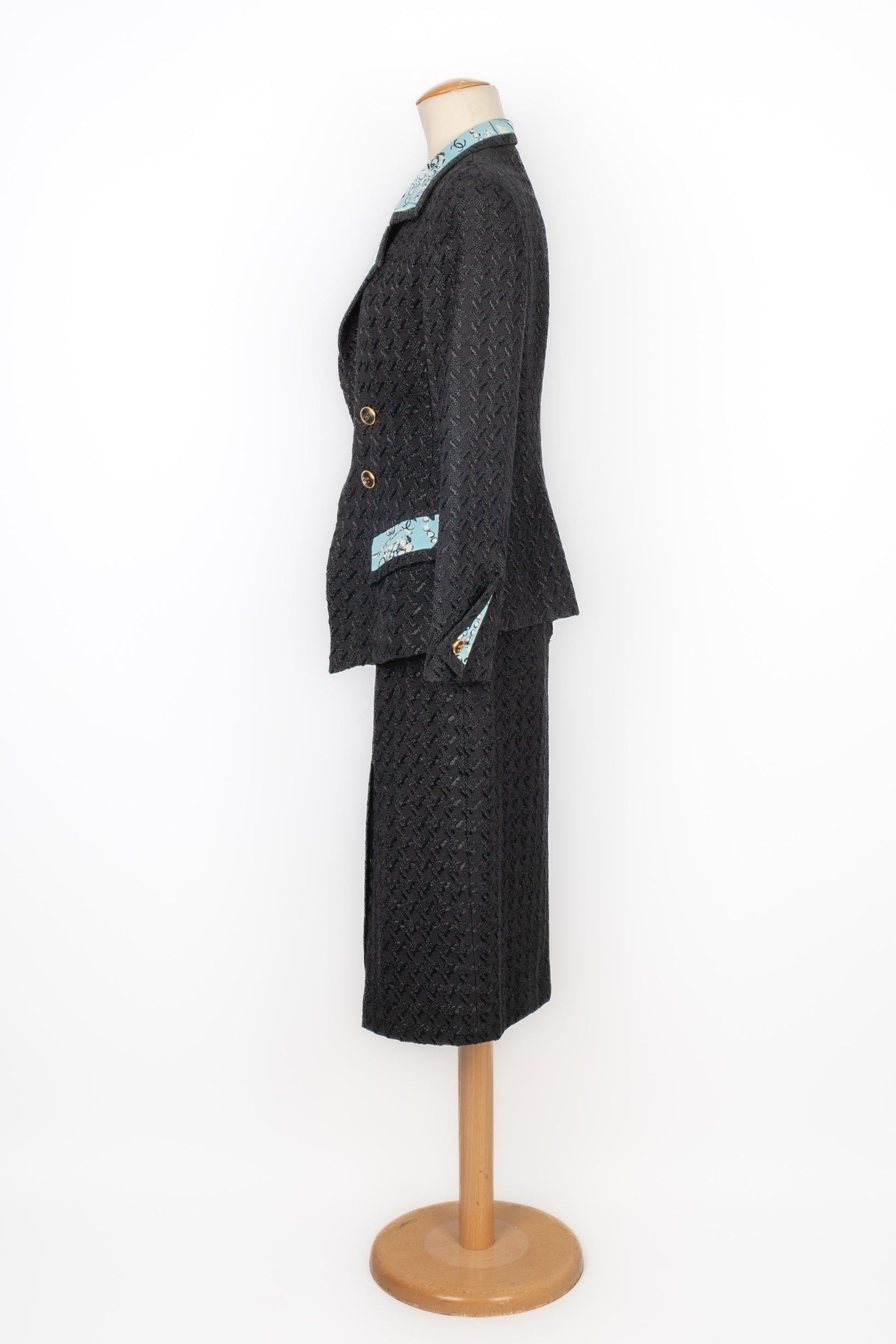 Chanel - (Made in France) Black tweed skirt suit with a printed blue silk lining. Size 38FR. 1993 Spring-Summer Collection under the artistic direction of Karl Lagerfeld.

Additional information:
Condition: Very good condition
Dimensions: Jacket: 42