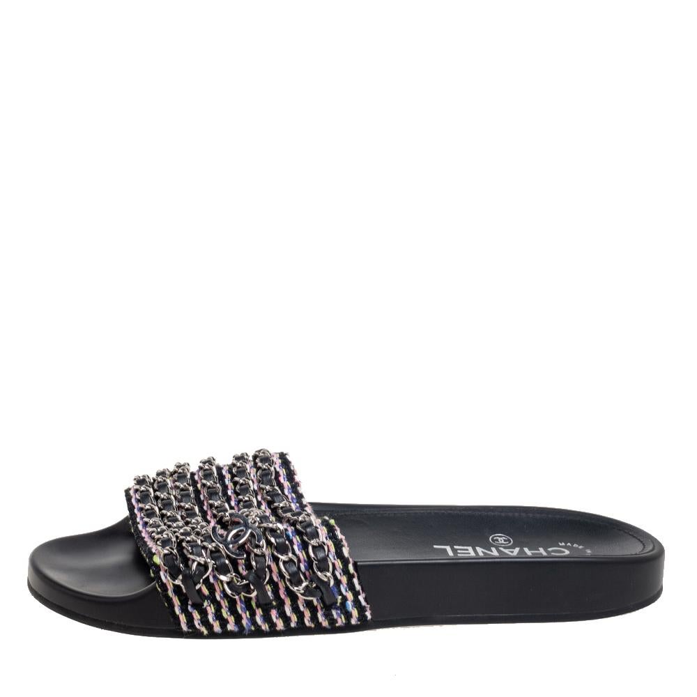 Chanel brings you these super comfy and relaxed pair of Tropiconic slides to elevate your style and give your feet comfort. This pair is made from black tweed, with chain detailing embellishing its upper. This pair of flats is adorned with