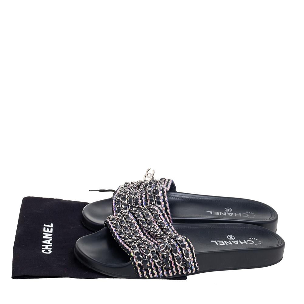 Chanel brings you these super comfy and relaxed pair of Tropiconic slides to elevate your style and give your feet comfort. This pair is made from black tweed, with chain detailing embellishing its upper. This pair of flats is adorned with