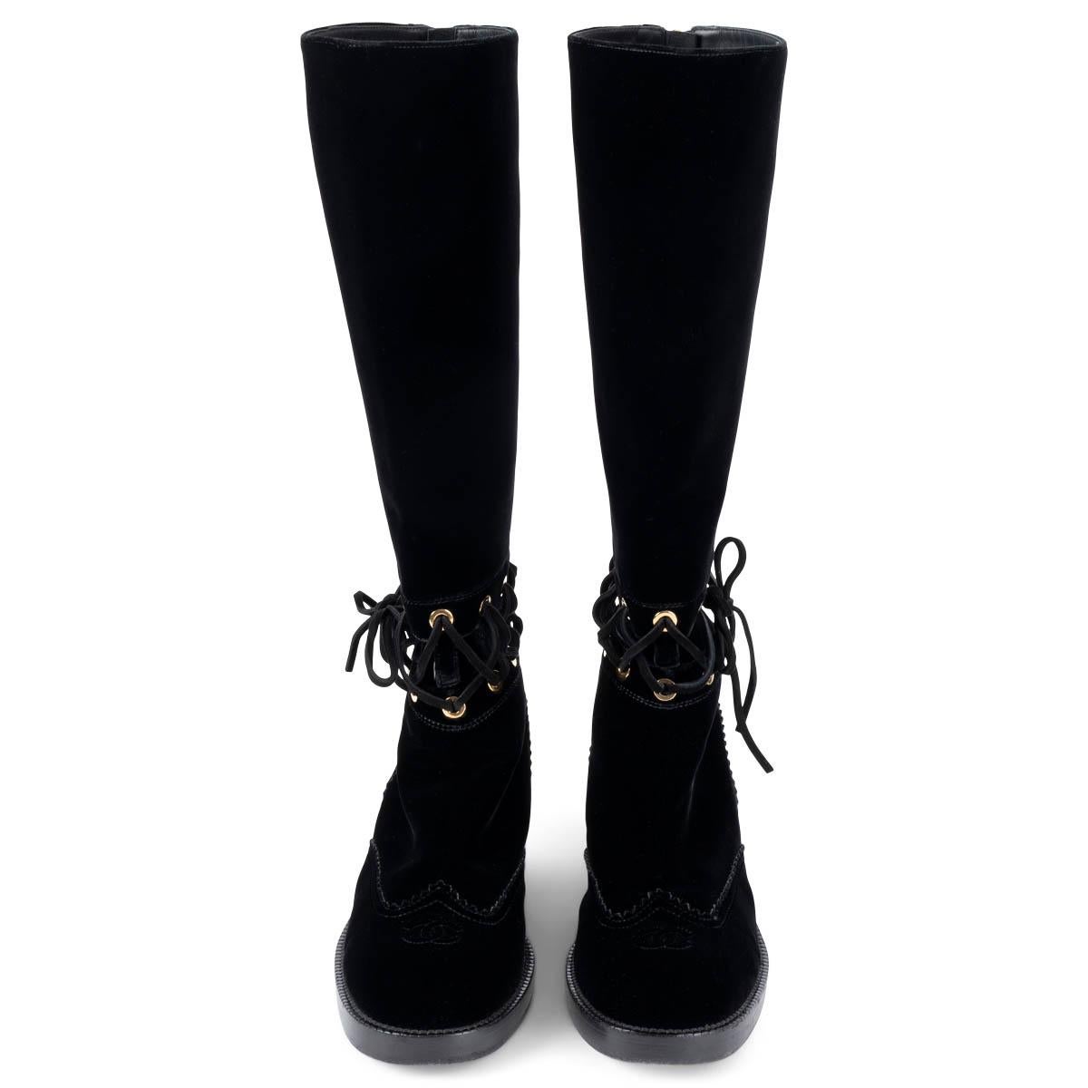 100% authentic Chanel 2016 interlocking cut-out knee-high riding boots in black velvet and leather. The design features a cut-out with suede laces, gold-tone hardware and a stacked block heel. Opens with a zipper on the back. Have been worn and are