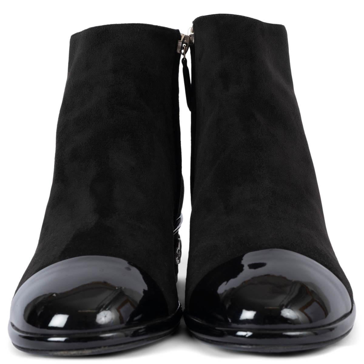 100% authentische Chanel Stiefelette aus schwarzem Wildleder mit schwarzer Lackleder Cap Toe. Das Design zeichnet sich durch silberfarbene Metall-Charms an der Ferse aus. Wurden ein- oder zweimal getragen und sind in ausgezeichnetem Zustand. 

2017