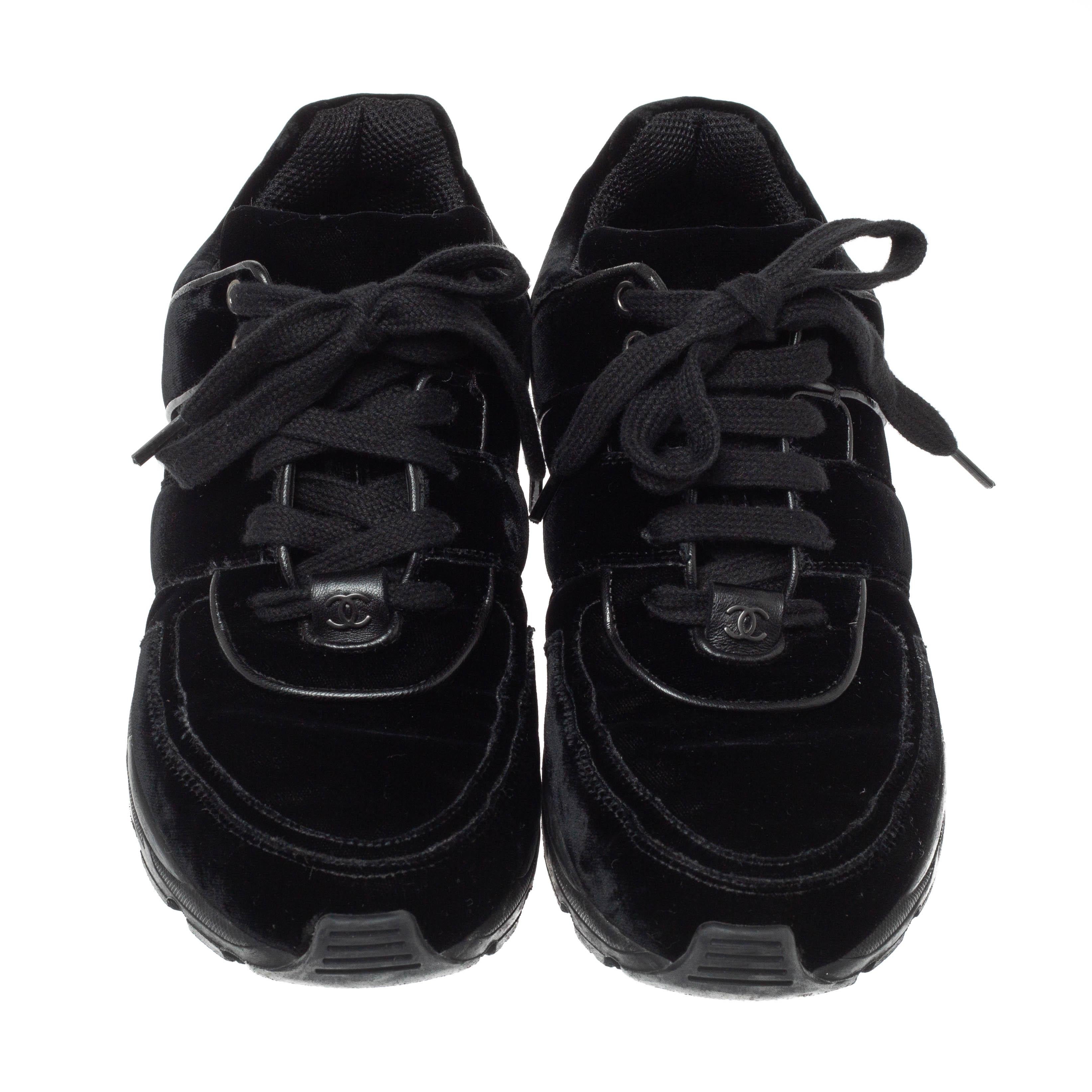 The time to feel trendy is now as Chanel brings you these superhit sneakers in black. They are crafted from velvet with leather trims, detailed with lace-ups and signature CC logo on the vamps, and set on highly comfortable rubber soles. You are