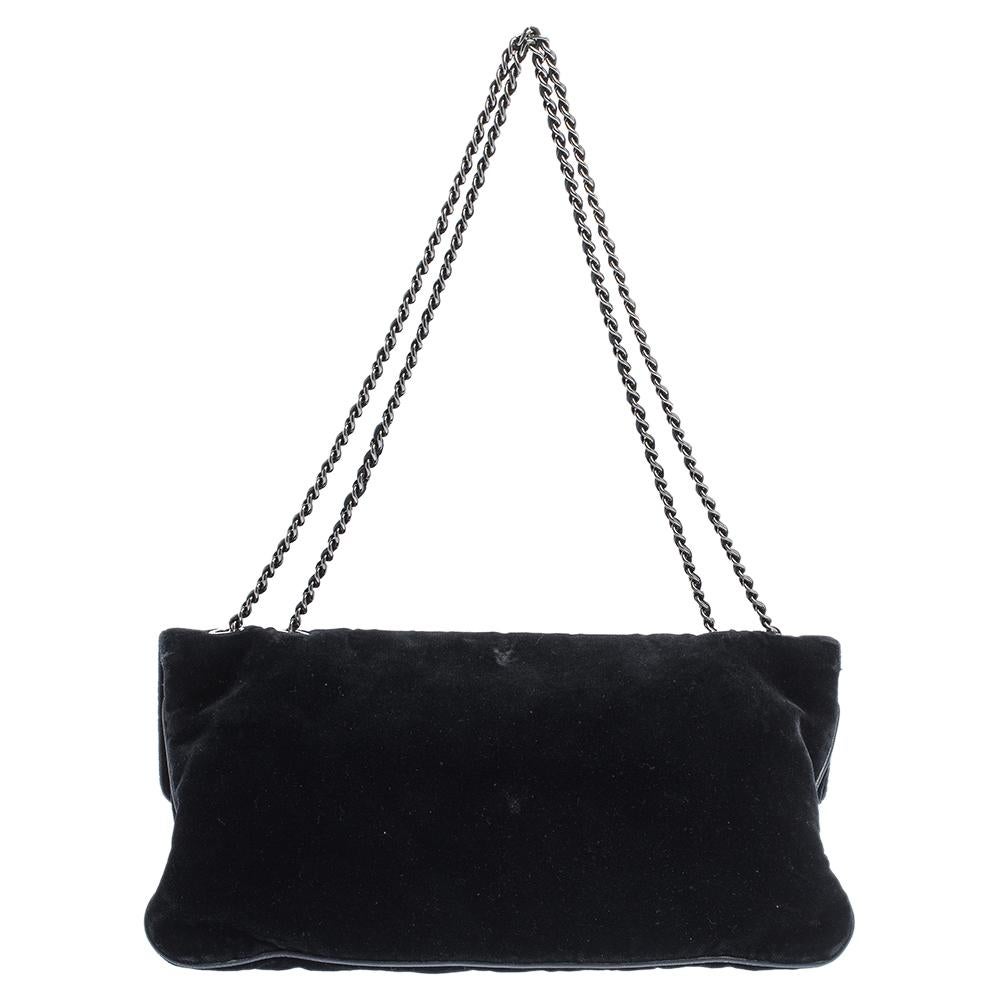 This Chanel Reissue is a buy that is worth every bit of your splurge. Exquisitely crafted from black velvet into an adorable shape, it carries the iconic Mademoiselle lock on the flap. The piece has silver-tone hardware, and chainlink handles just