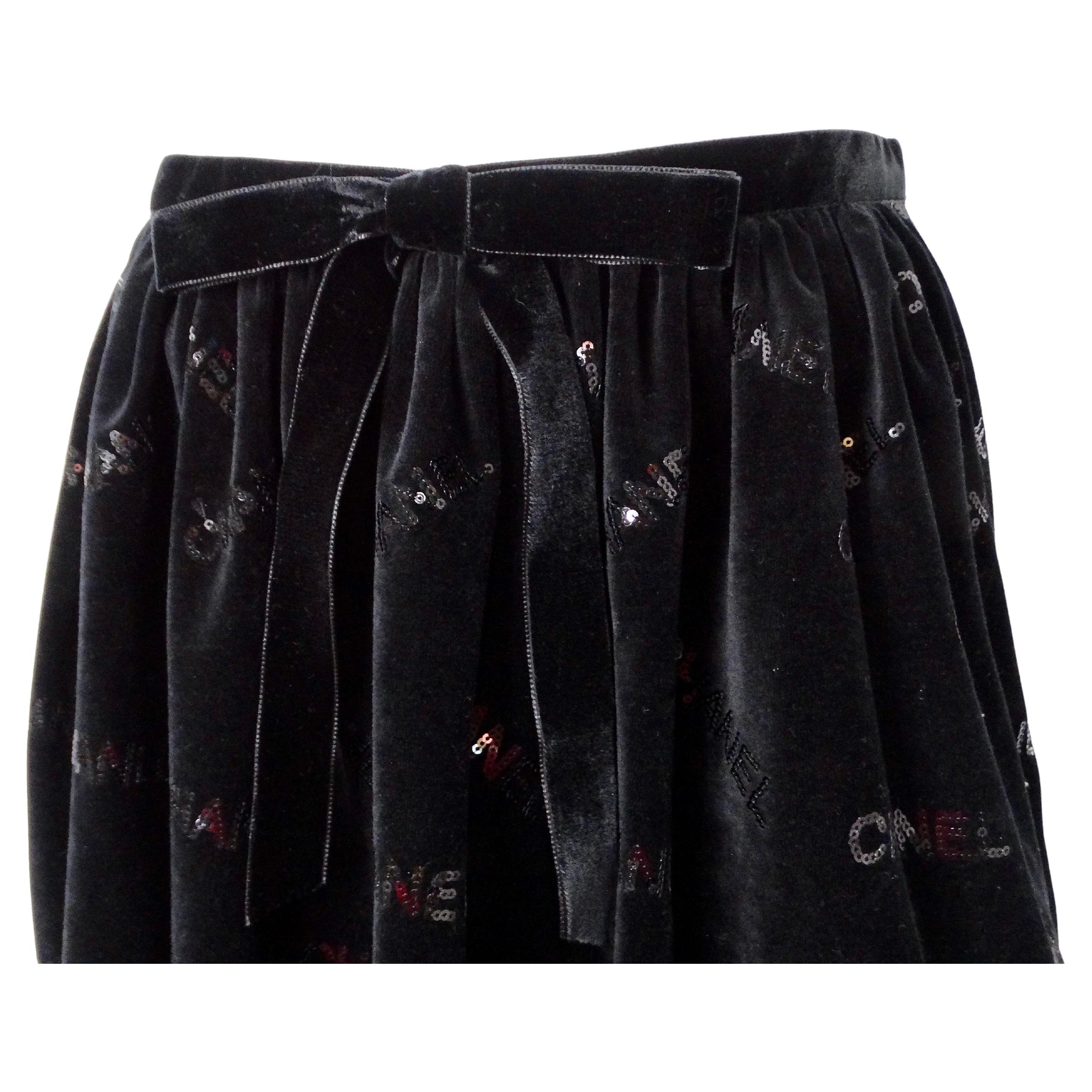 La mini-jupe logo à sequins en velours noir 2022 de Chanel est une pièce étonnante qui respire le luxe et la sophistication. Confectionnée en velours noir moelleux, cette jupe est ornée d'une multitude de paillettes épelant le logo emblématique de