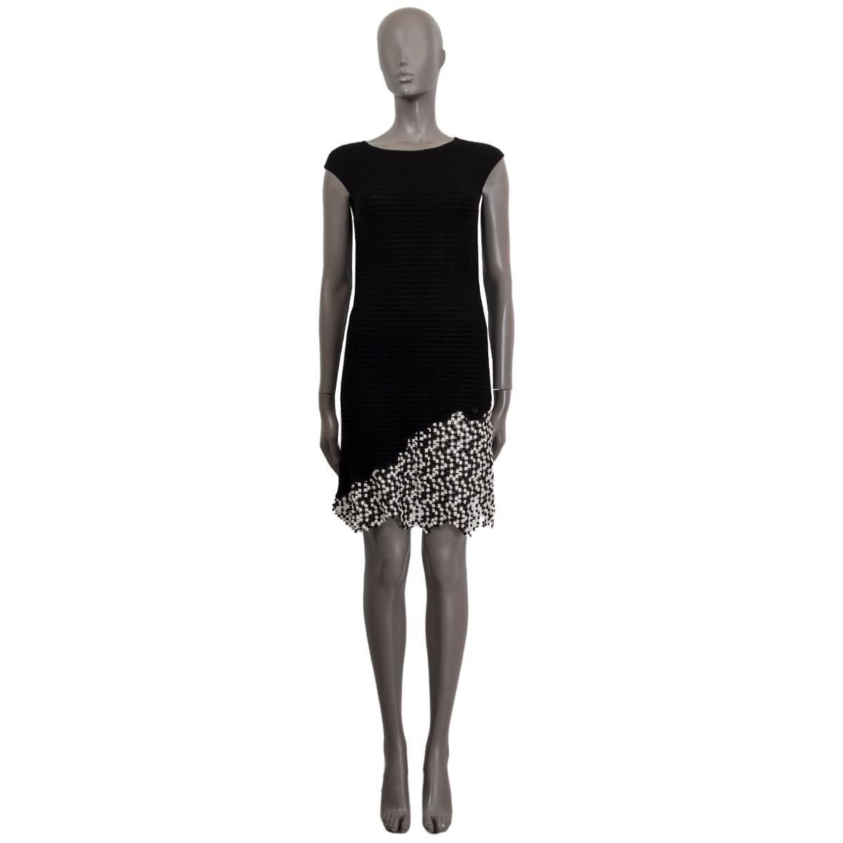 100% authentic Chanel sleeveless knit sheath dress in black viscose (66%), cotton (20%) and nylon (14%) with a round neck. Has  black and white square knit details at the botton. Unlined. Has been worn and is in excellent condition. 

2011