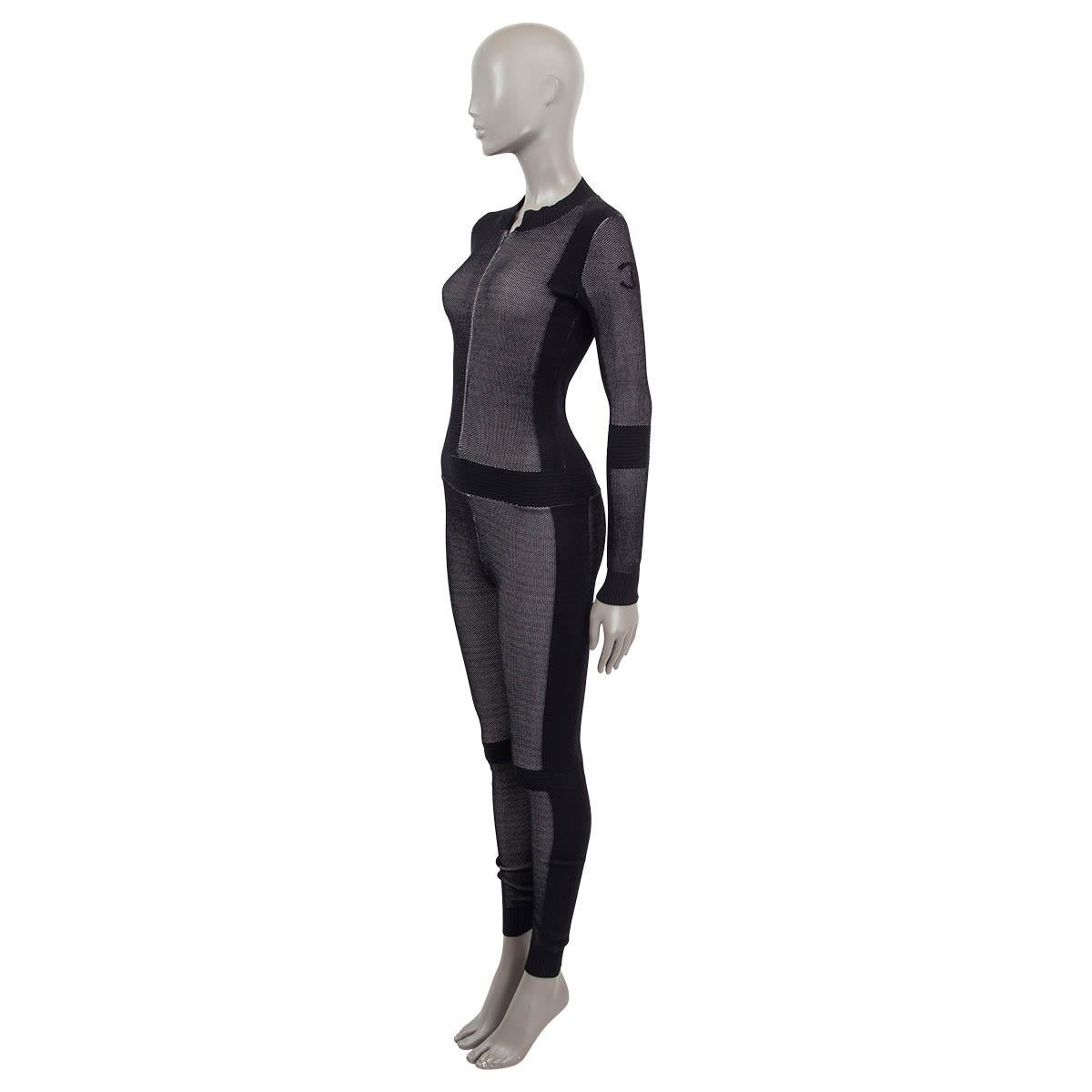 Combinaison technique en maille stretch 100% authentique Chanel en viscose noire (83%) et polyester (17%). Présence de côtes à la taille, aux coudes et aux genoux. S'ouvre avec une fermeture éclair sur le devant. Non doublé. A été porté et est en