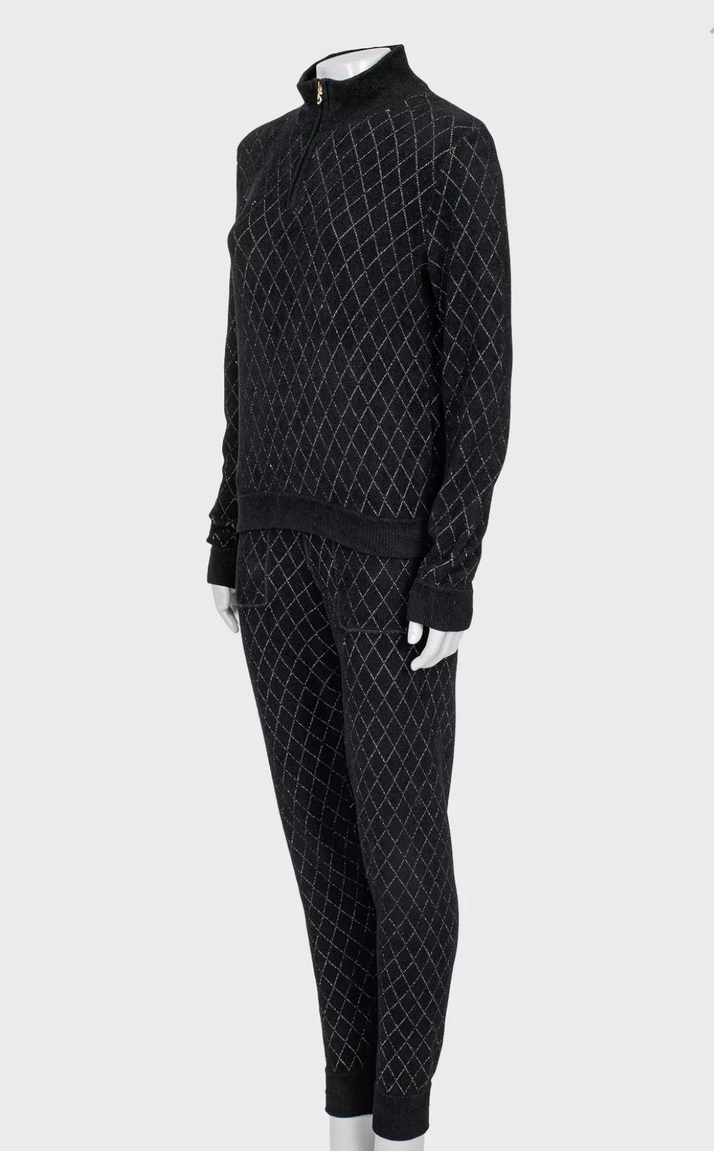Eleva il tuo guardaroba con questo sofisticato set a due pezzi di Chanel. Realizzato in classica viscosa nera, questo ensemble emana un'eleganza senza tempo e uno stile moderno. La giacca slim-fit è dotata di un'elegante chiusura con cerniera e di