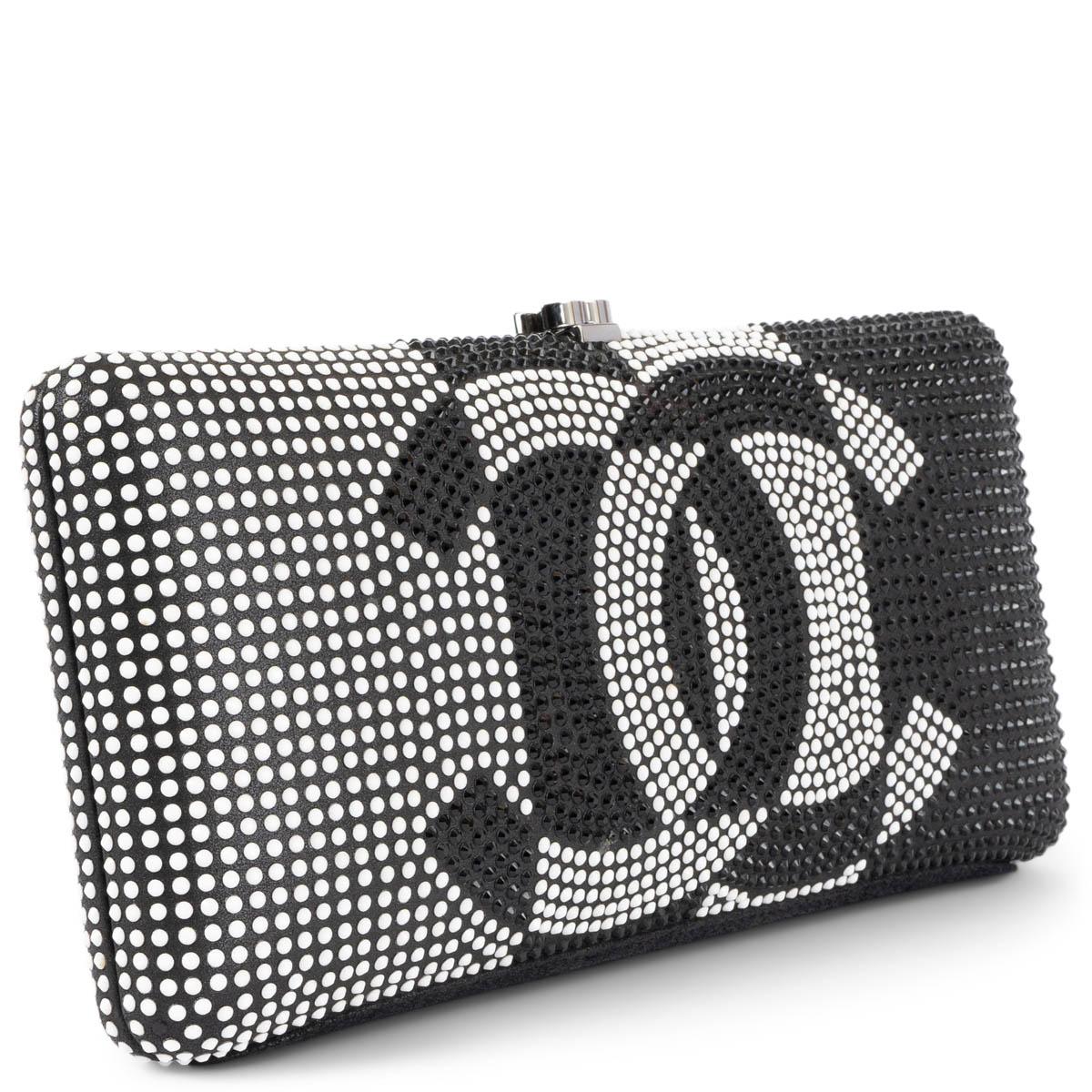 100% authentic Chanel CC Minaudière black satin hard case clutch with chain embellished black & white strass and ruthenium CC logo closure and shoulder-strap. The interior is lined in black satin. Has been carried and three black and one white