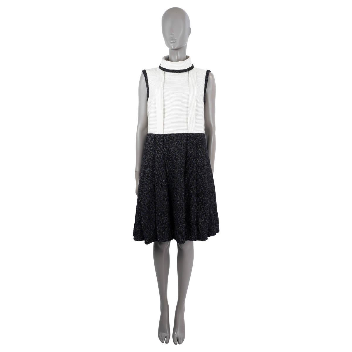 100% authentic Chanel sleeveless dress made of an ivory striped top part in cotton (95%) and polyamide (5%) with a rolled collar neckline, a Camellia embellished buttoned back, pleated deatils and tweed trim. The knee-leght skirt part is made of