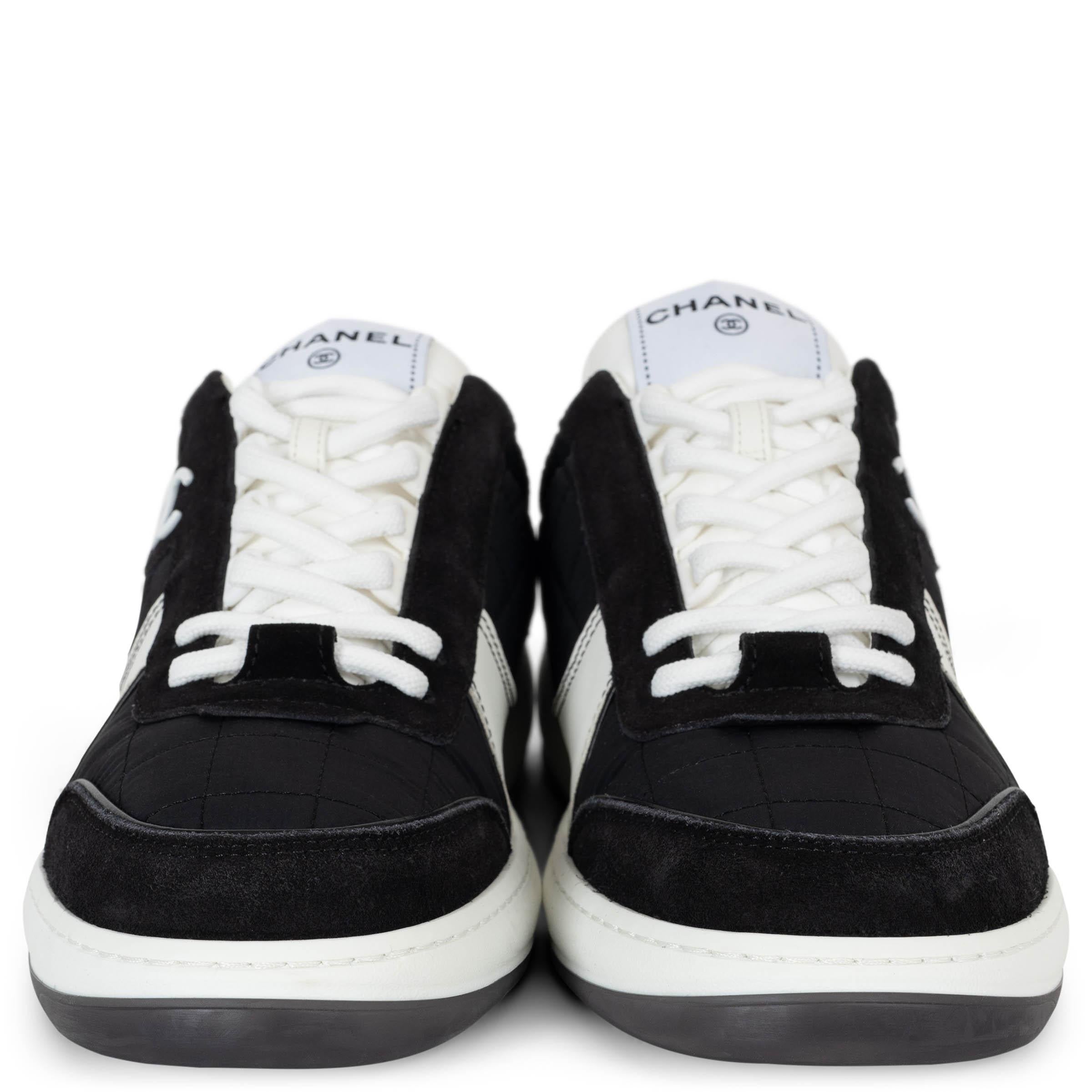 This 100% authentic Chanel low-top sneakers in black quilted nylon offer a sleek fusion of sporty sophistication and timeless design. Accented with black suede and white leather trims, they feature classic round toes for a comfortable fit. A white