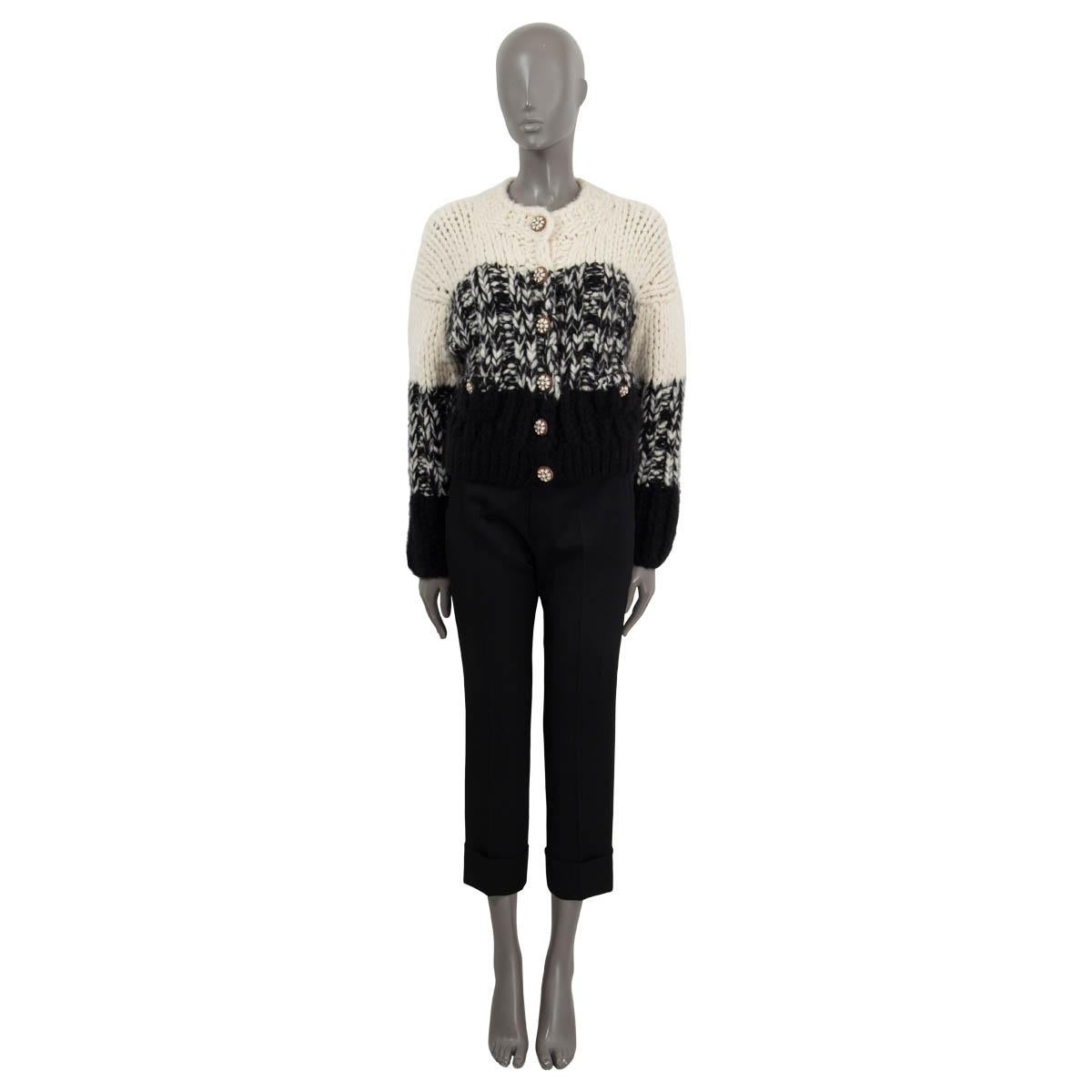 100% authentic Chanel Fall/Winter 2019 chunky knit cardigan in black and white cashmere (90%) and silk (10%). Features two buttoned pockets on the front and long sleeves. Opens with six buttons on the front. Unlined. Has been worn and is in