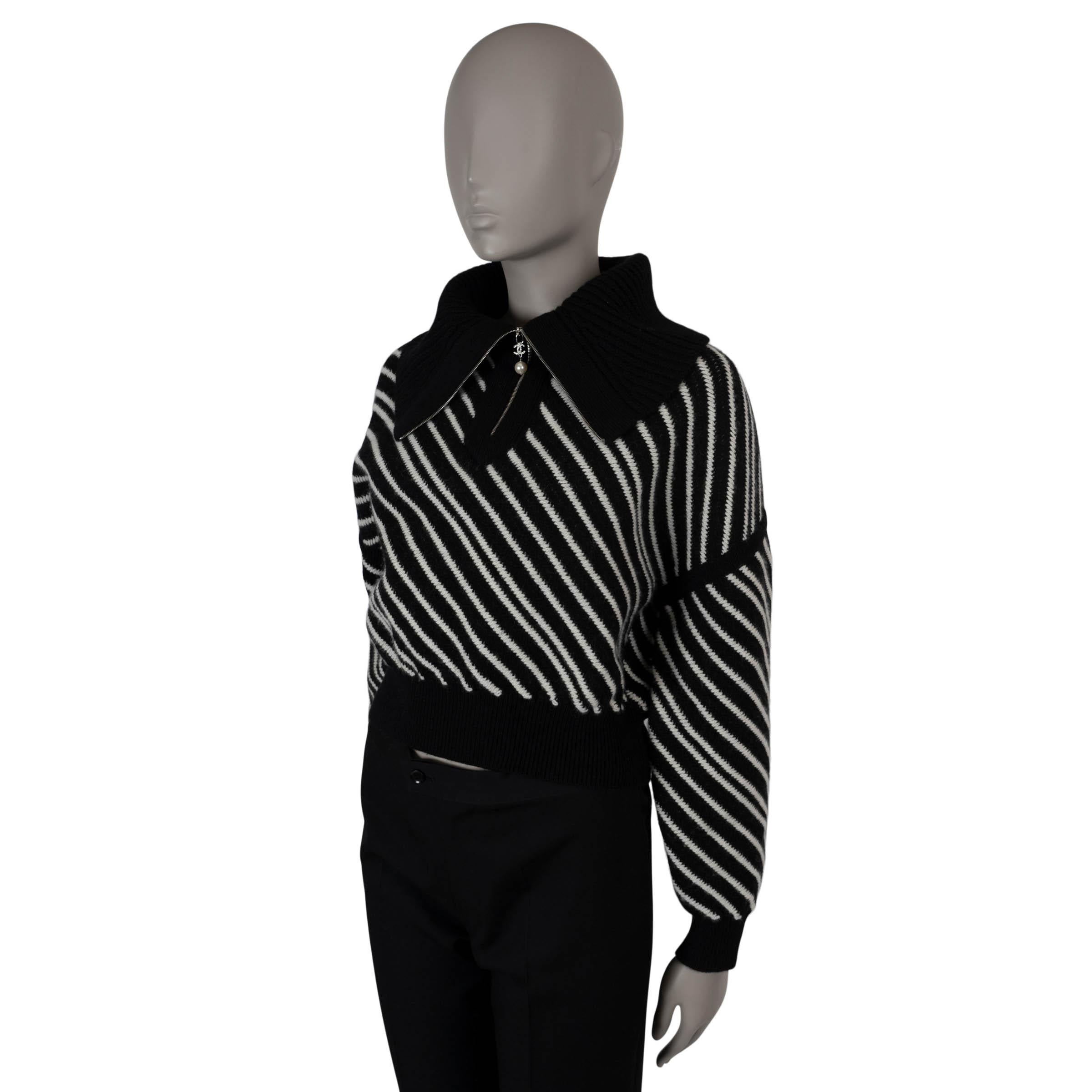 This 100% authentic Chanel sweater is crafted from luxurious black and white diagonal striped cashmere (100%). It features a cropped, boxy silhouette with dropped shoulders, a sailor collar with a half zip that transforms into a turtleneck when